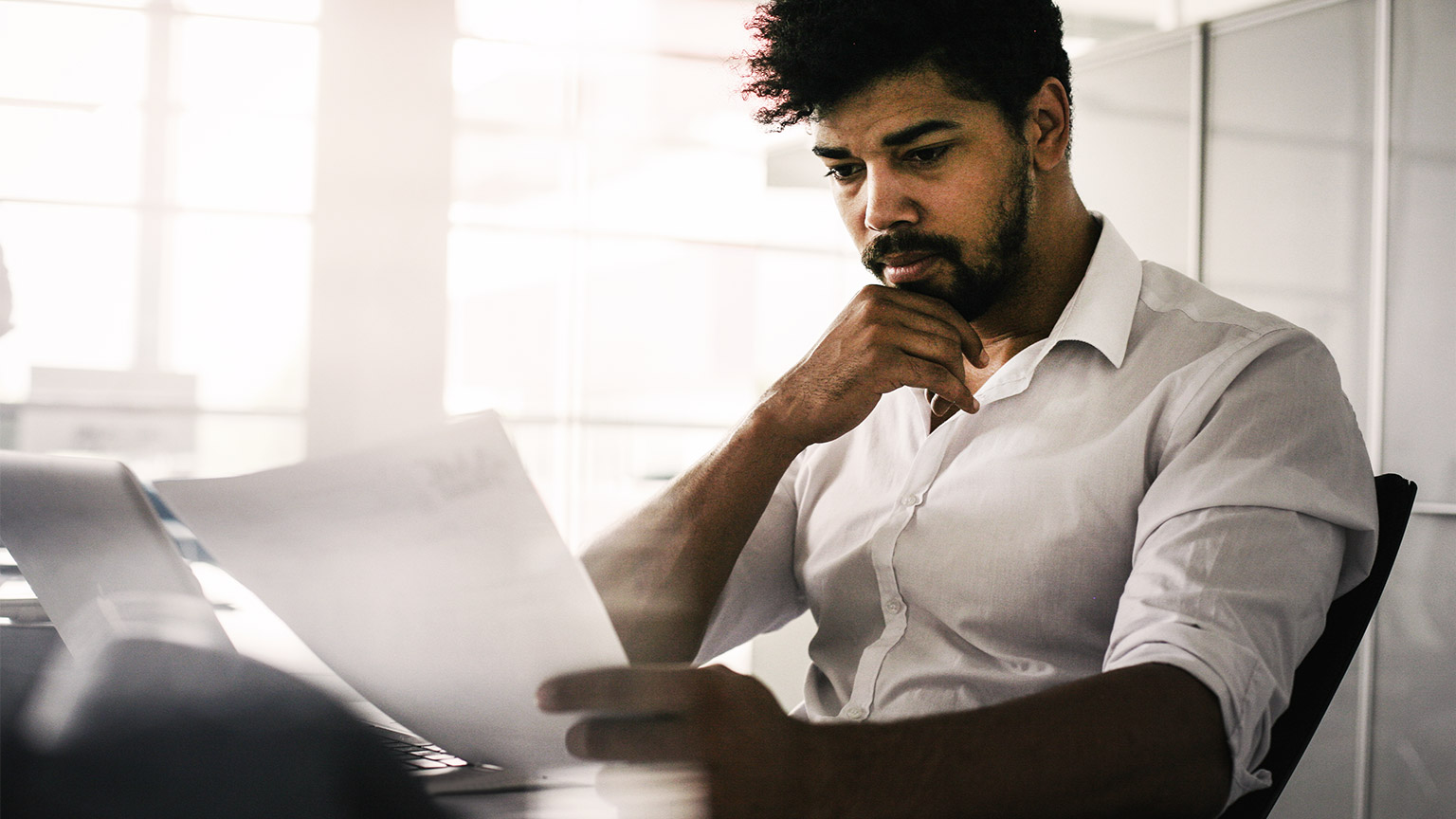 A professional seated at their desk, reviewing a terminology document