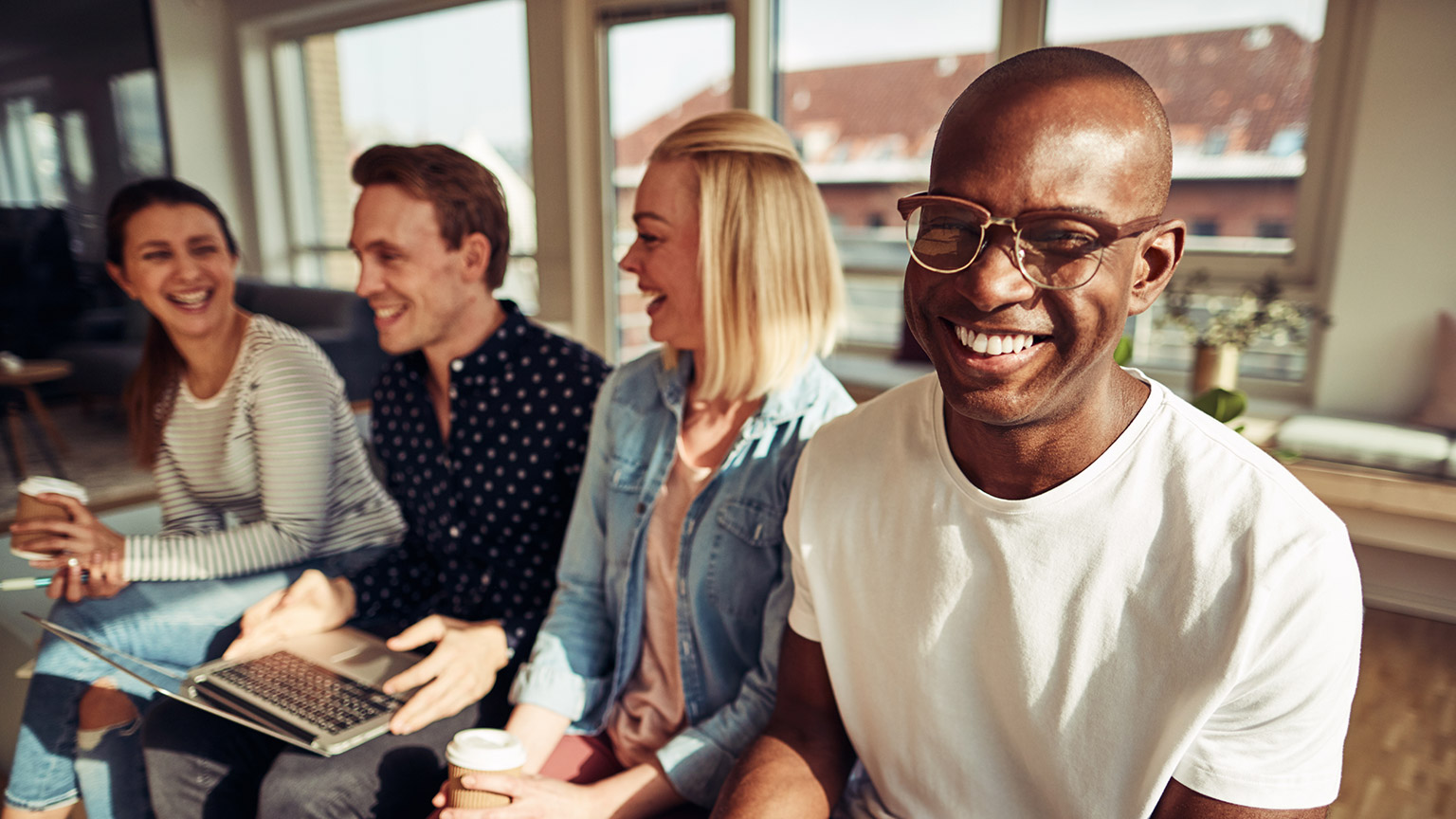 A diverse work group discussing a prject in a relaxed environment