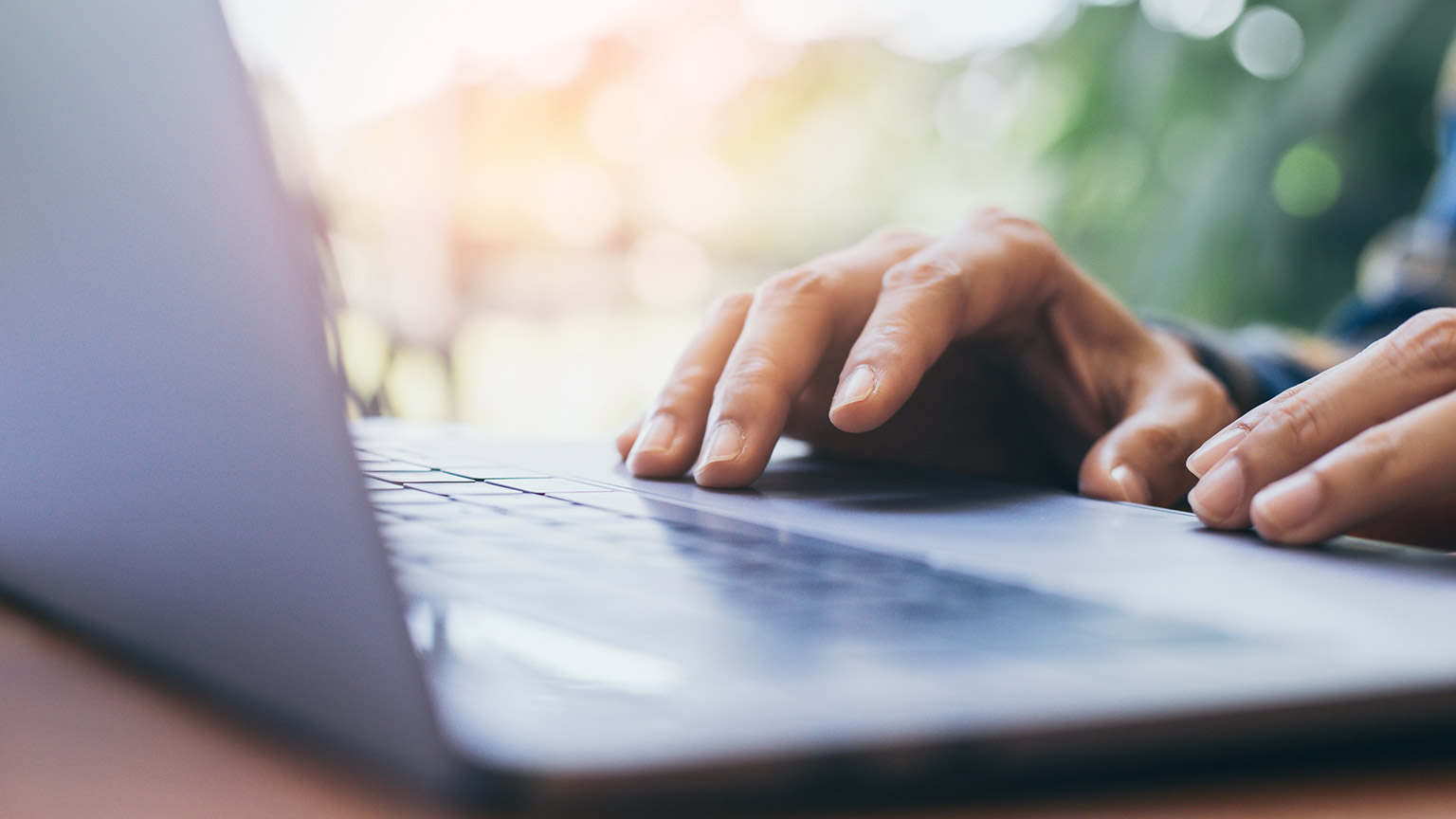 A close view of a person working on a site using a laptop