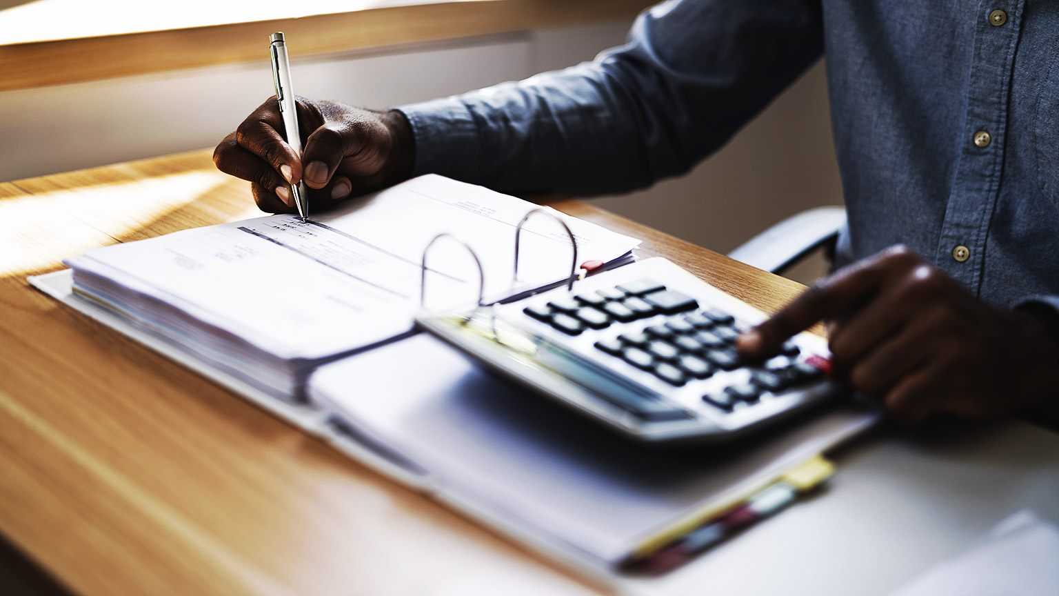 A person writing on a accounting ledger