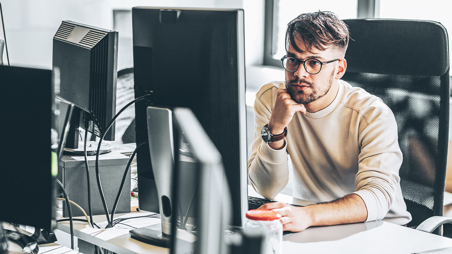 A programmer working on a project on a desktop computer