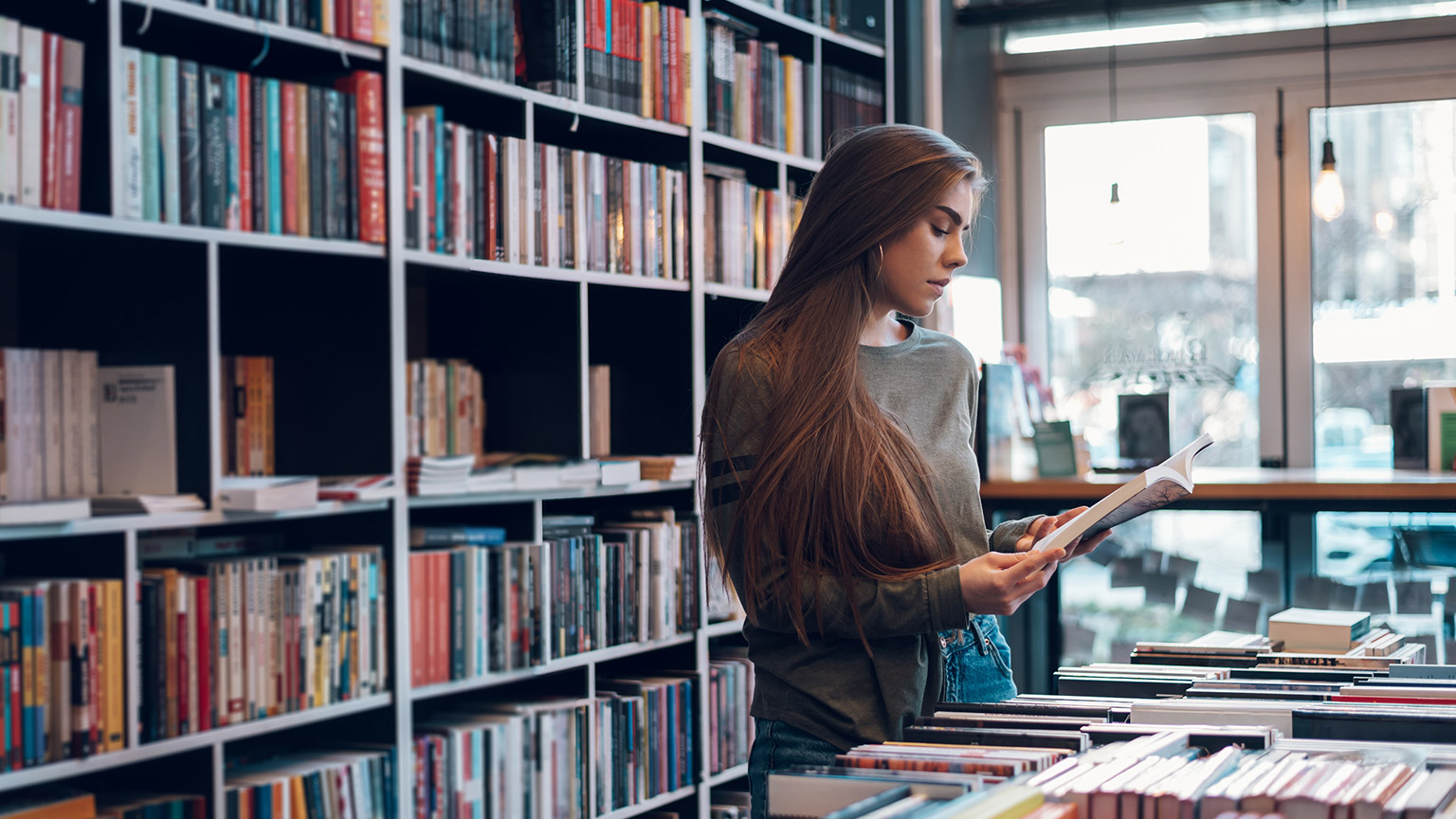 A student reading reference material in a library