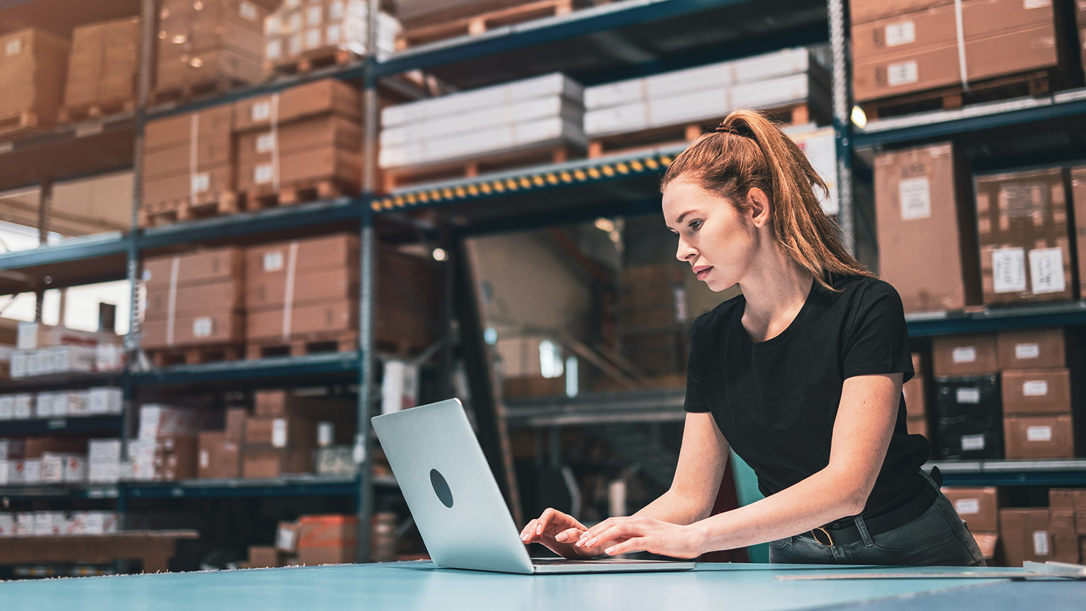 A person entering purchasing information into a laptop