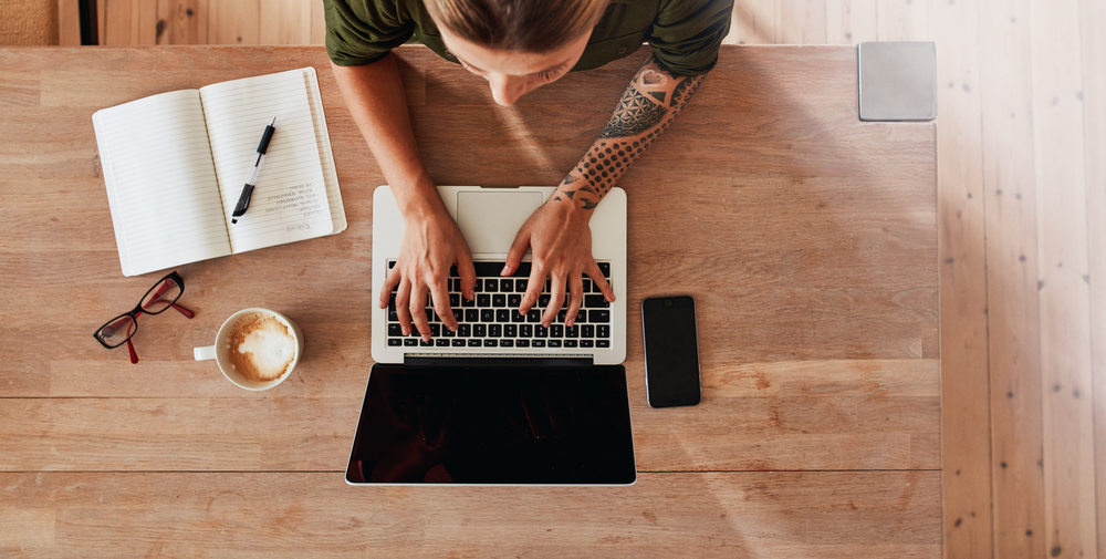 531418441  Top view of woman hands typing on laptop