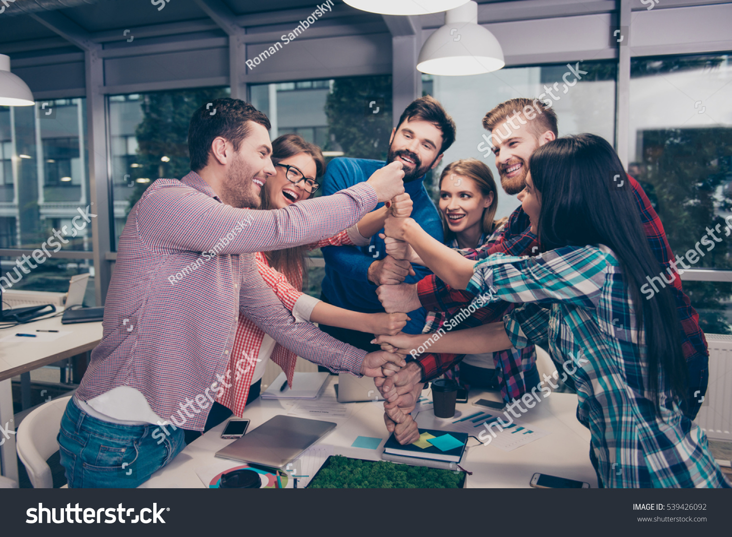 happy business people putting their first on top of each others in celebration