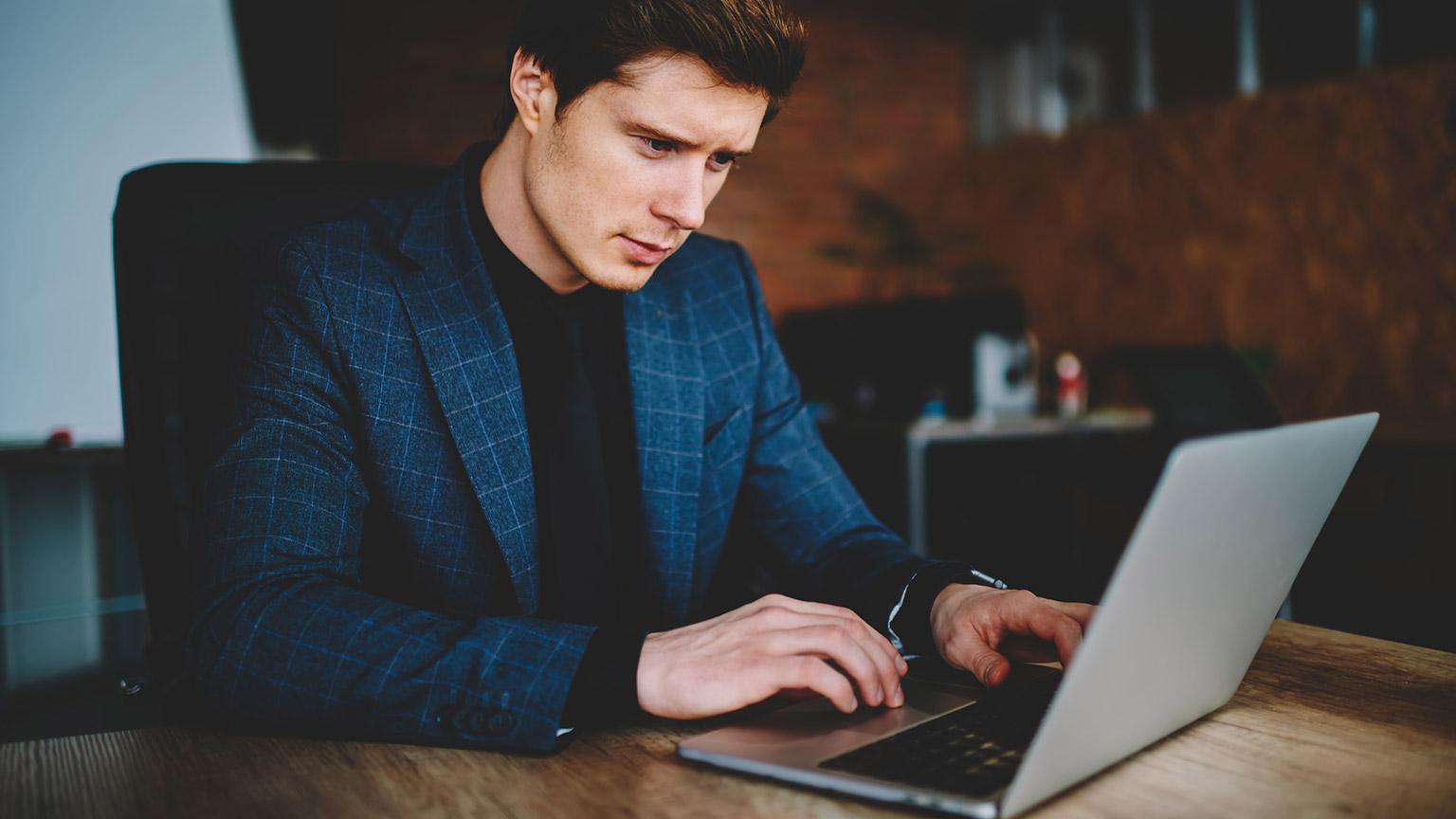 An accountant reading legislation on a laptop in an office