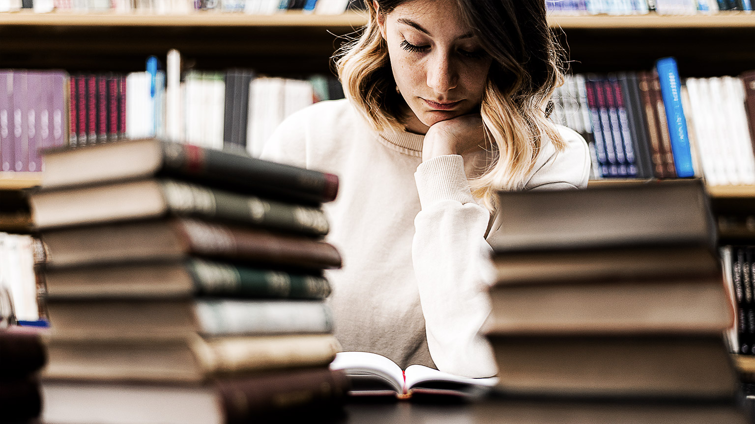 A person reading books in a library