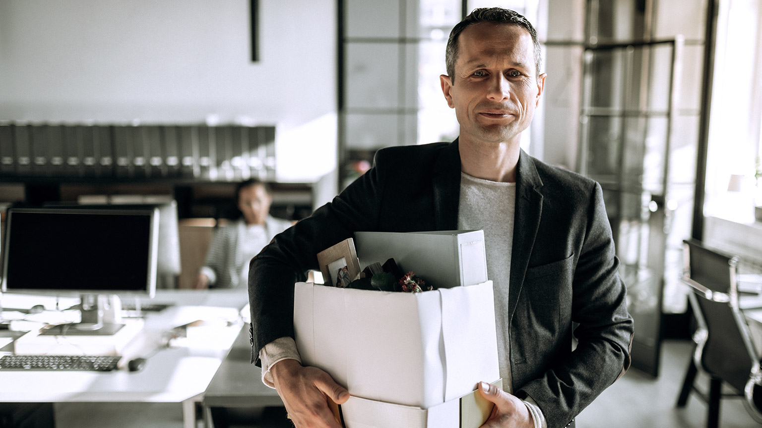 Man leaving office holding box