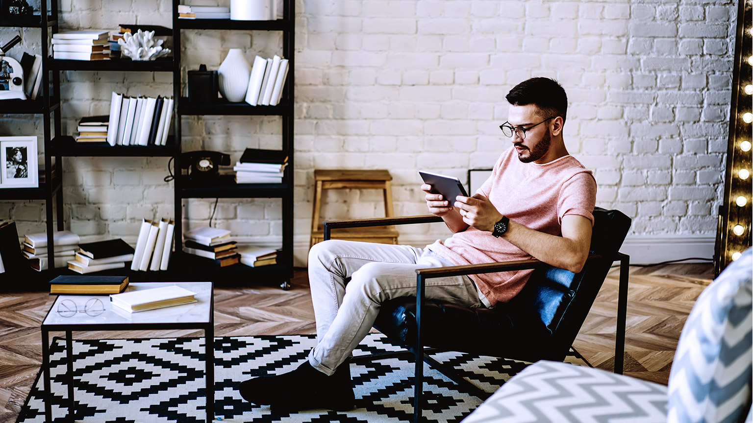 man sitting on chair with tablet