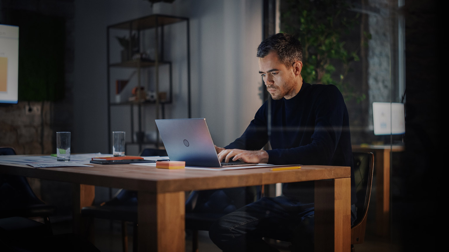 A business manager working on a project forecast on a laptop