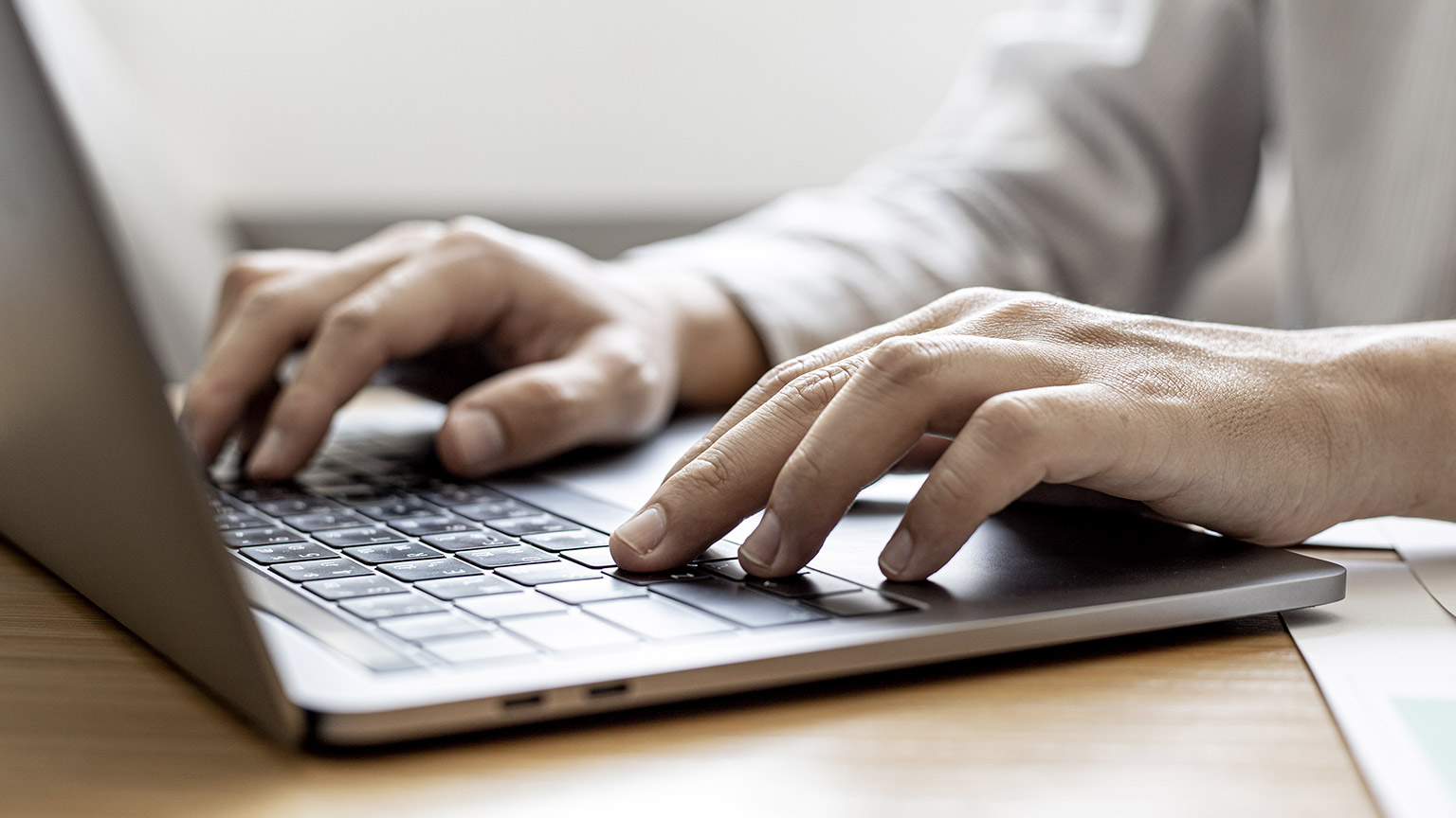 hand of man typing on laptop