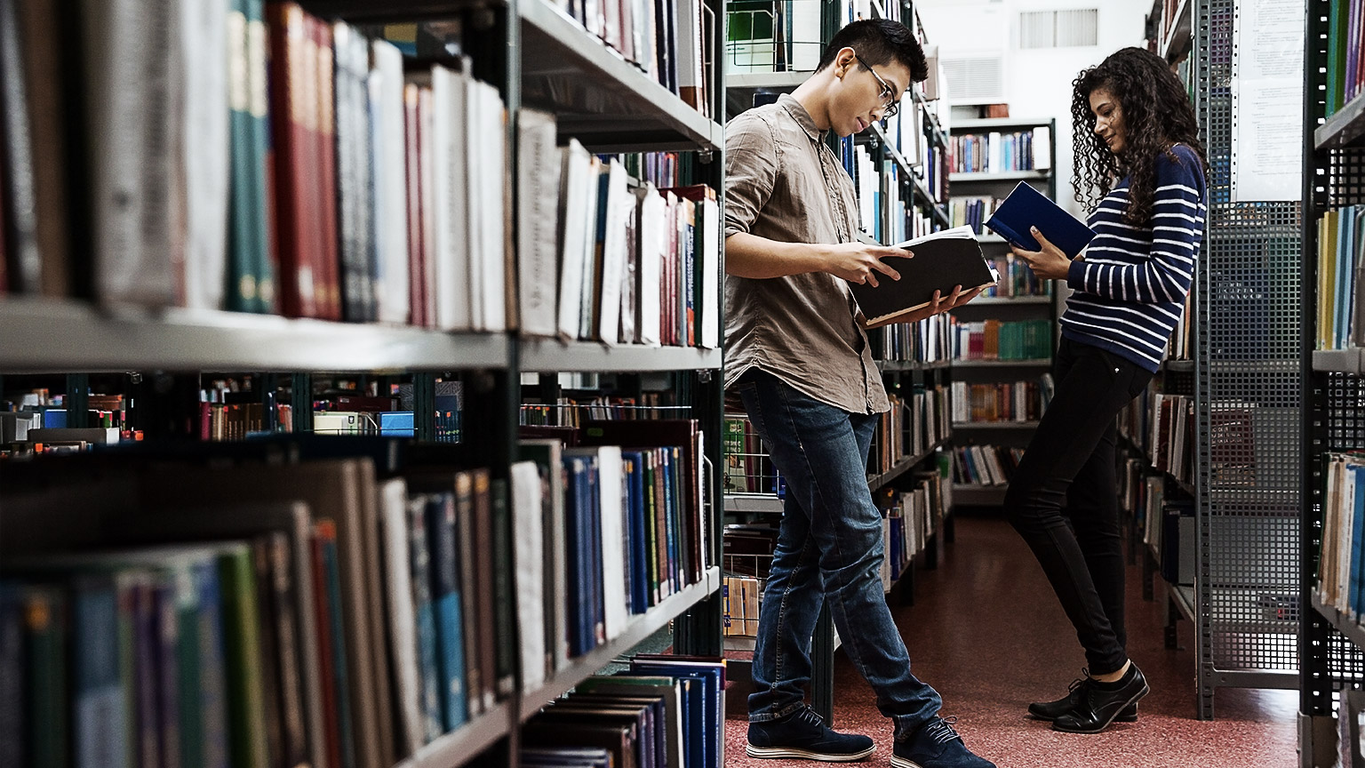 A couple of people reading in the library