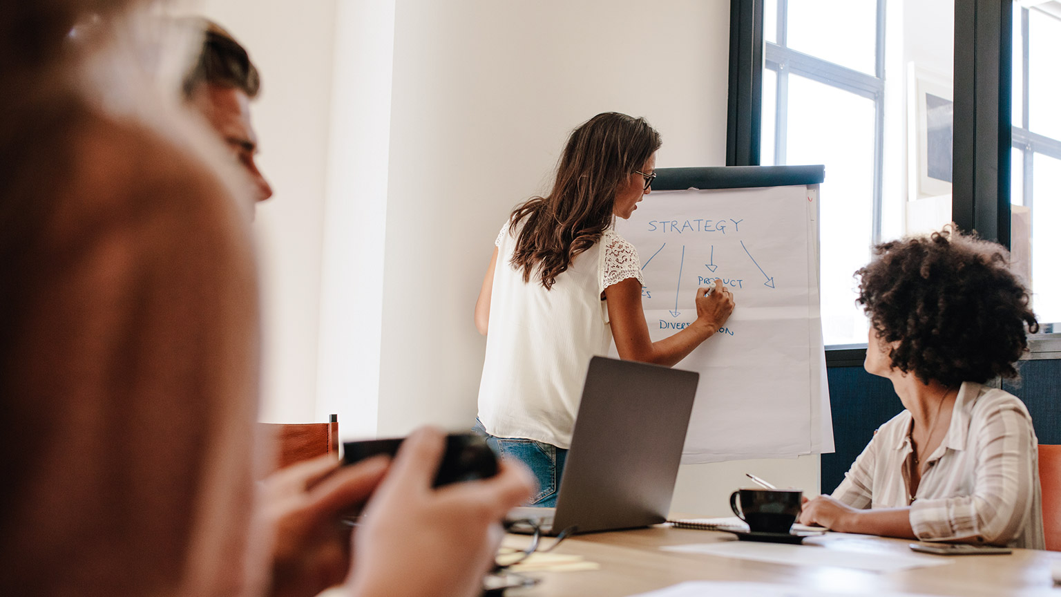 A wide shot of a work group discussing a project