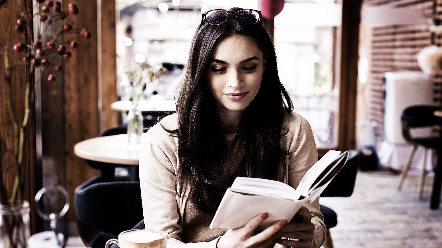 A person reading a book in a cafe