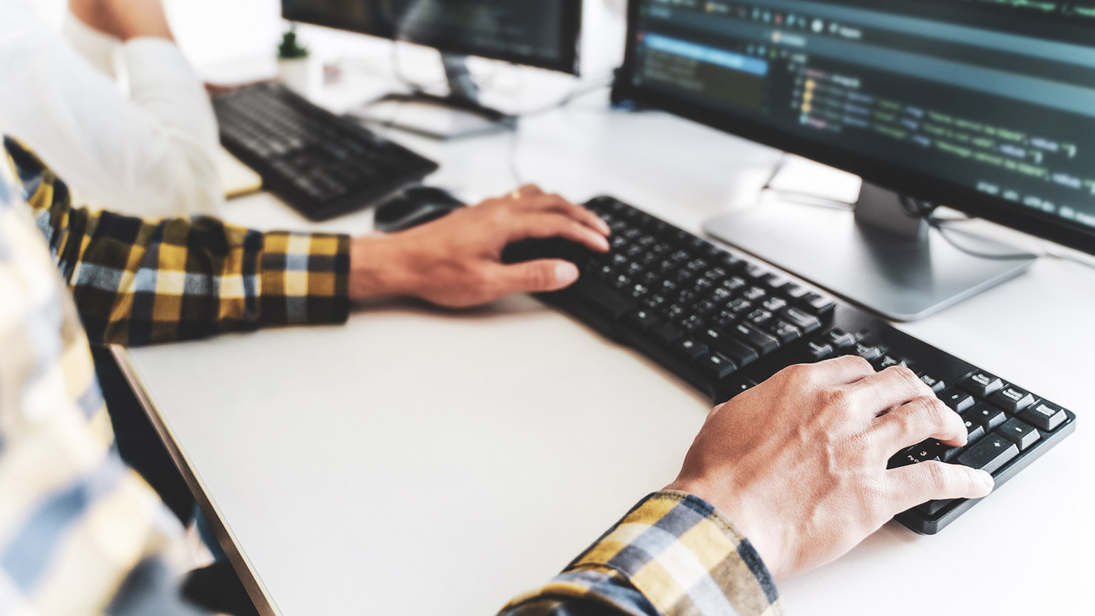 A close view of a programmer working at a desk