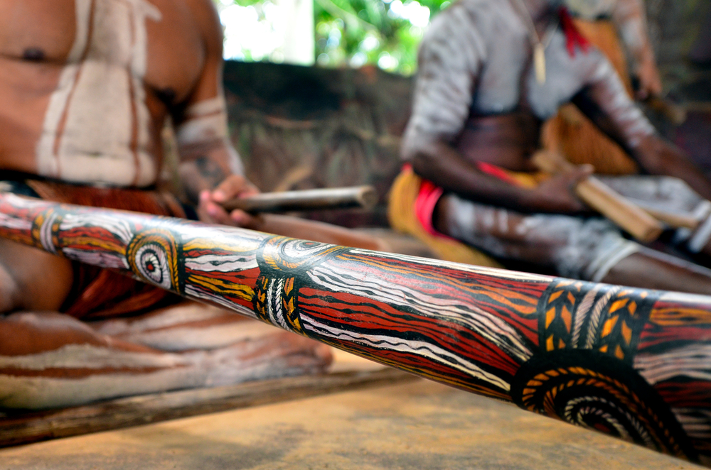 Australian Aboriginal men playing music on didgeridoo during Aboriginal culture show in Queensland, Australia