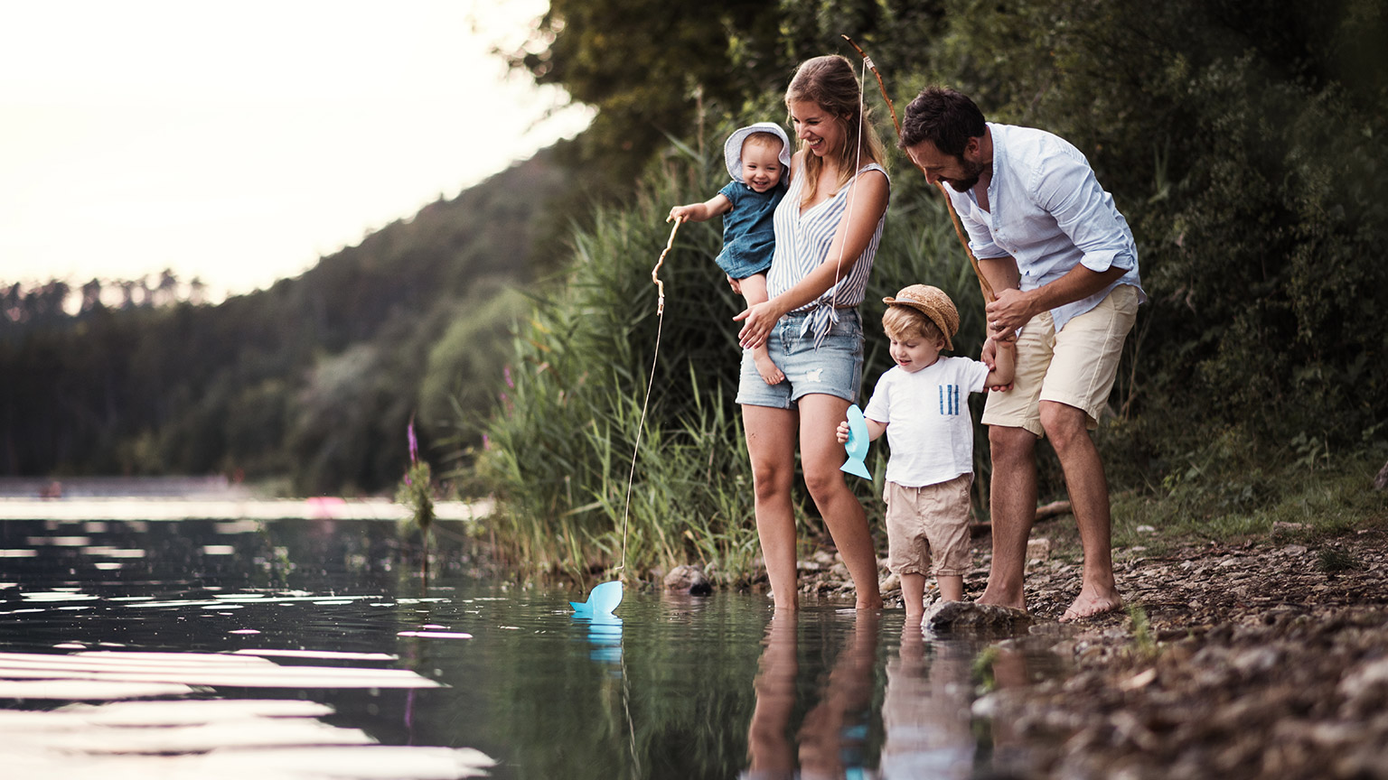 A young family enjoying time in an outdoor setting by a lake