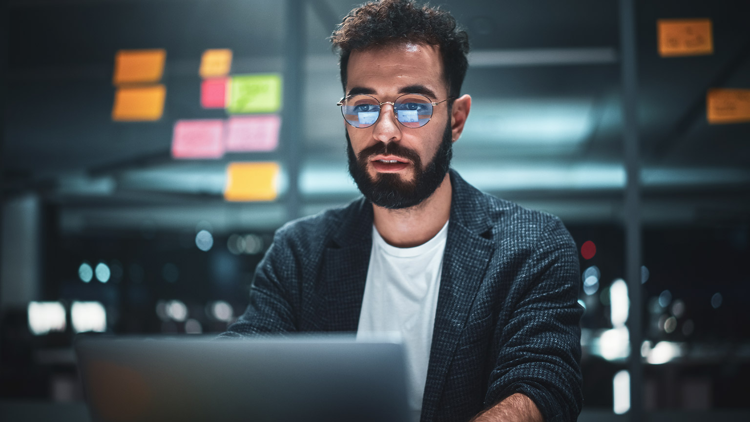 A data analyst working on a presentation in a dark office