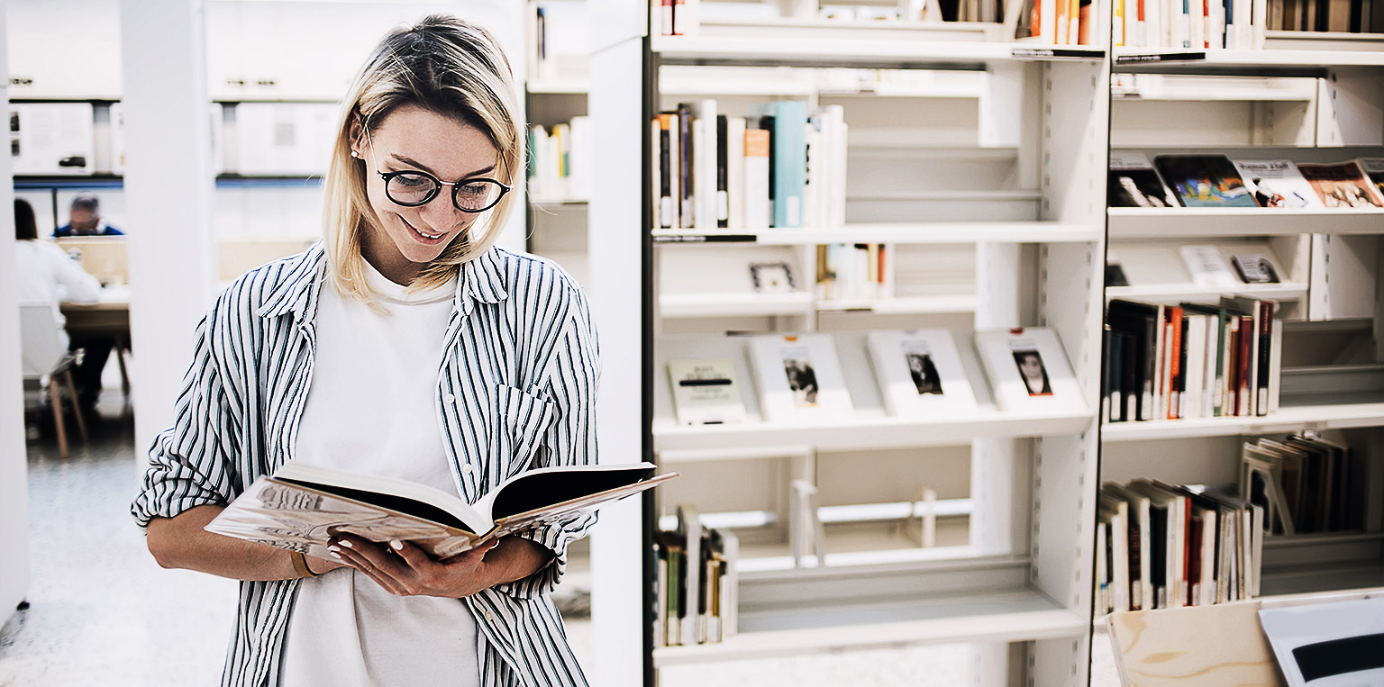 A person reading a book in a library