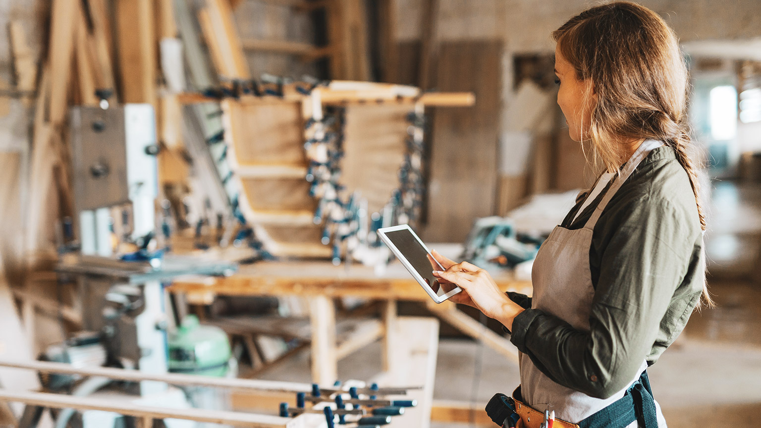 A small business owner entering business costs onto a tablet device