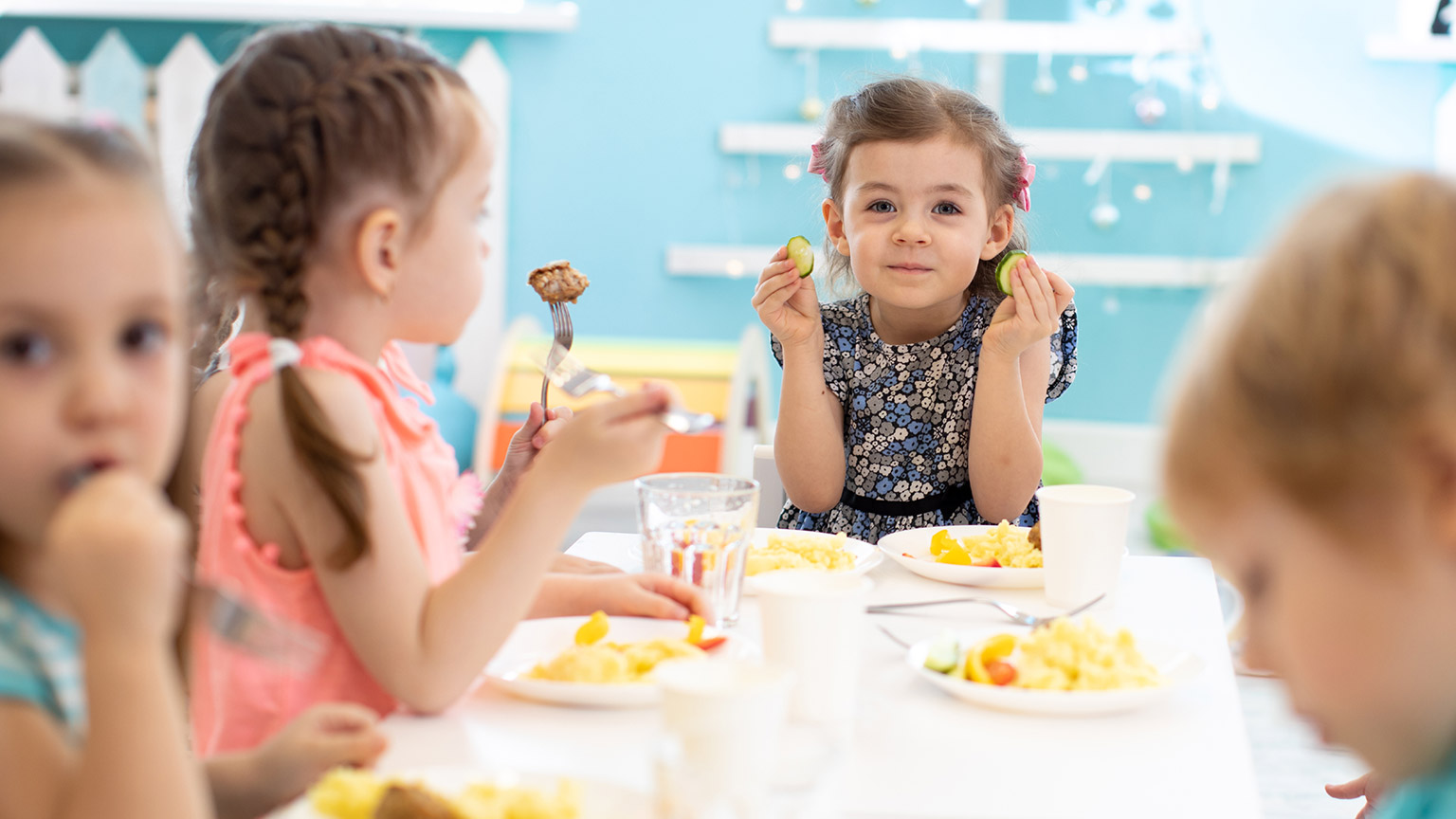 A group of kids sitting at a table eating