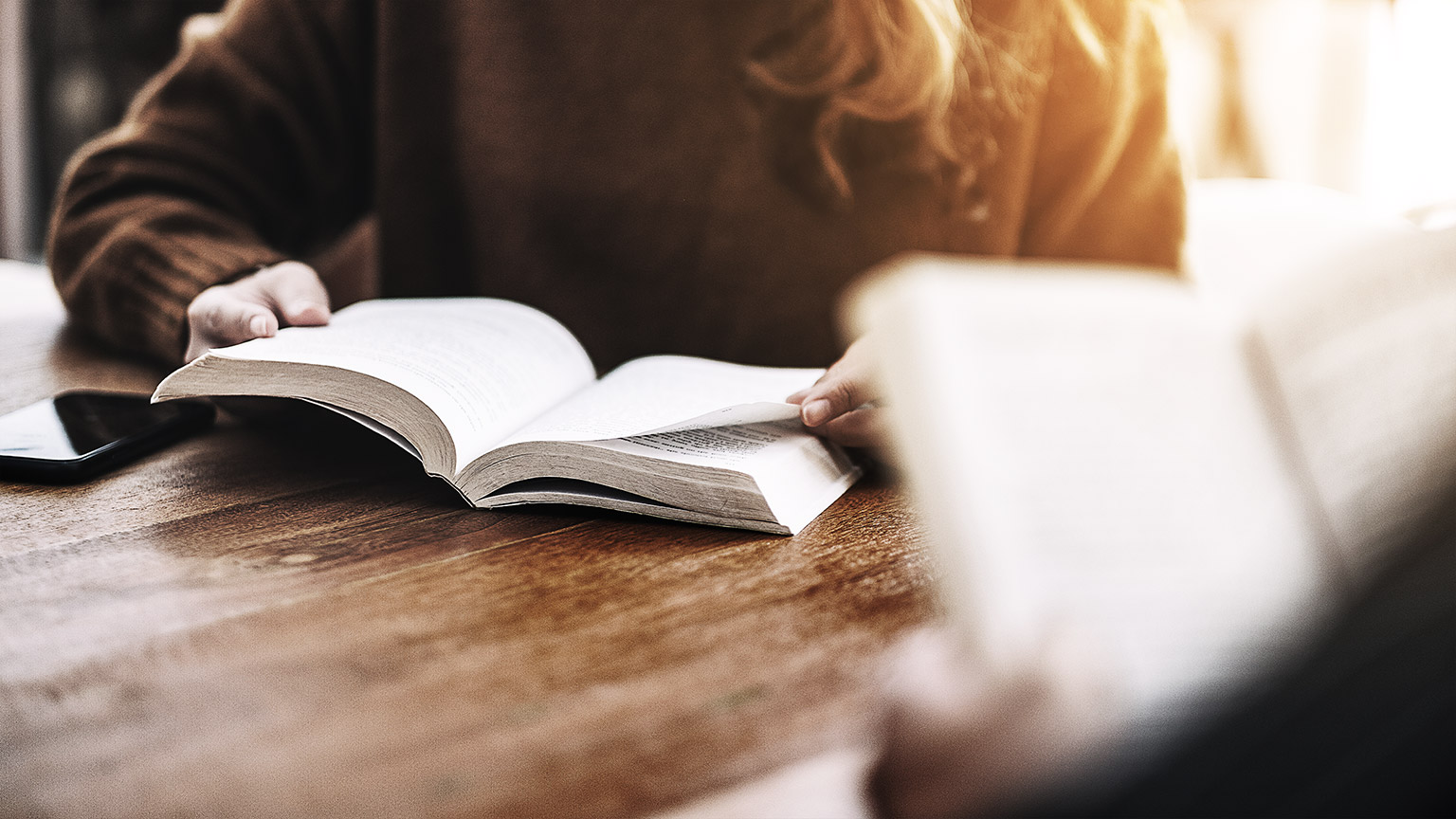 A couple of persons reading in a table