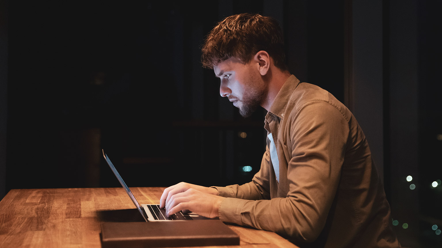 A student working on a laptop at night