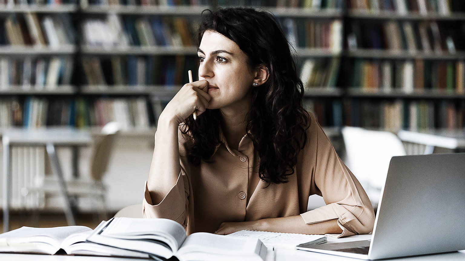 A person reading and reflecting in a library