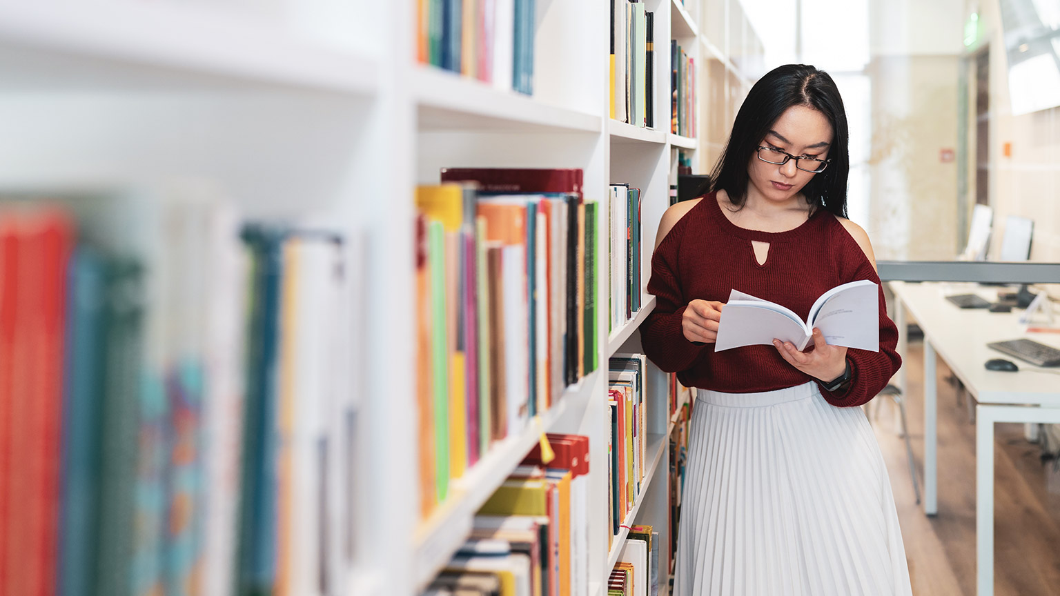 A person in a library reading a book