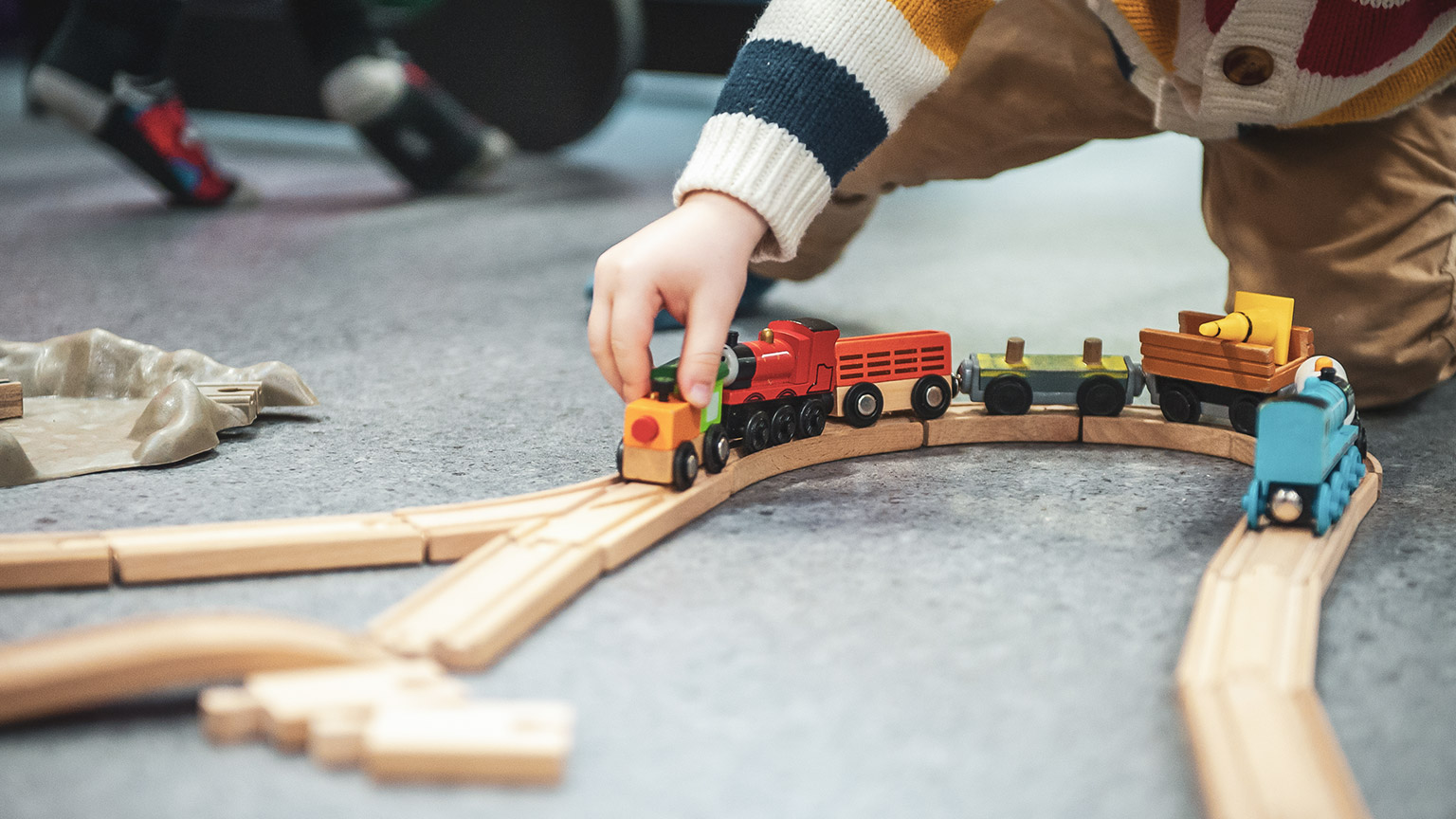 A close view of a child playing with toys on the floor