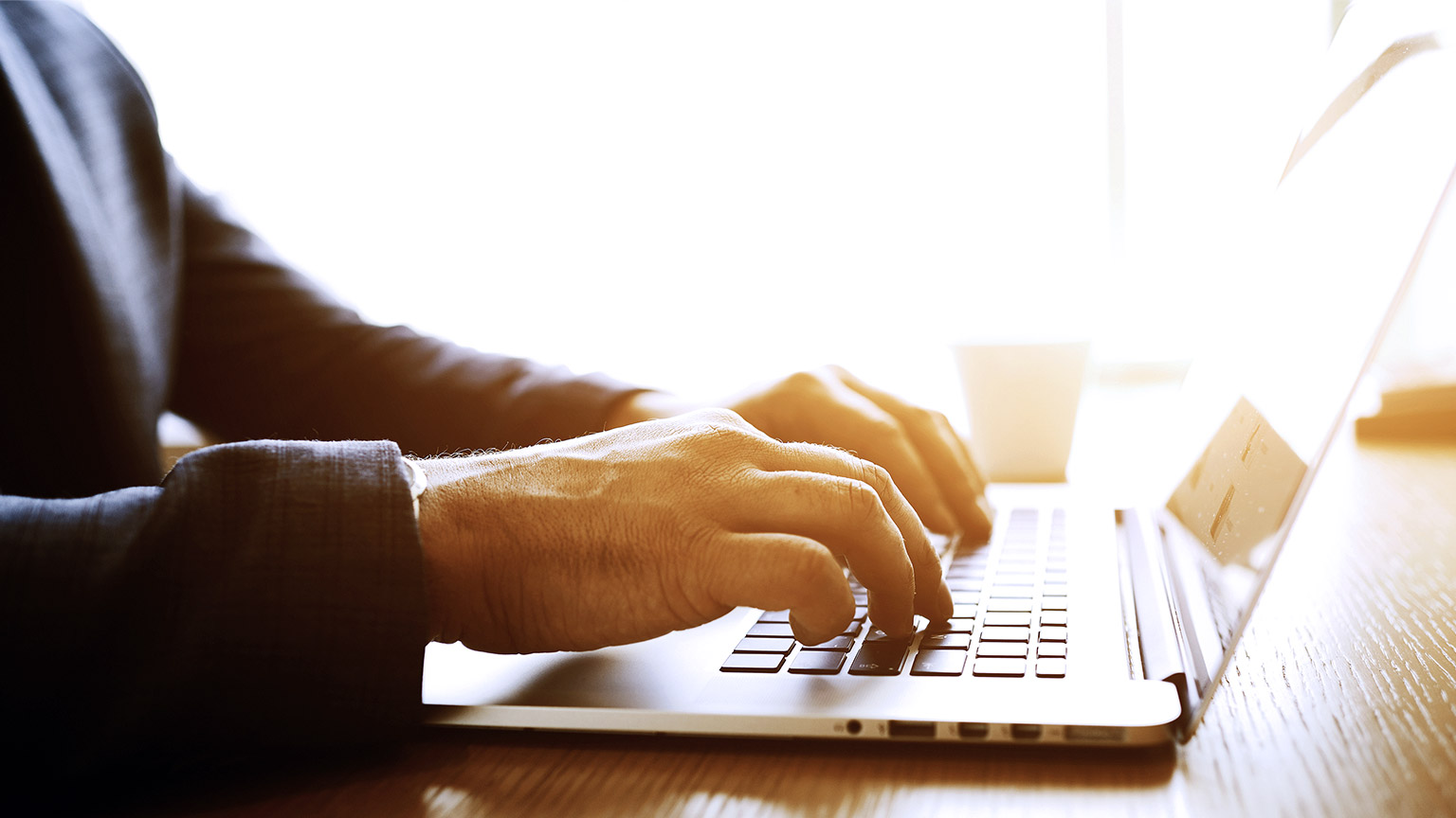 Close-up hand of man working on laptop