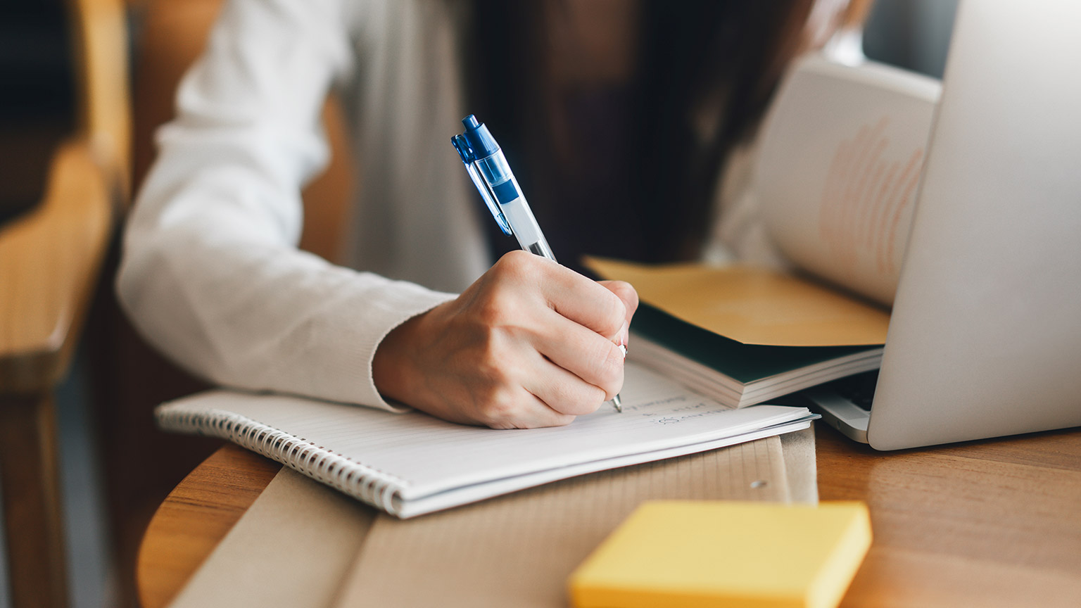 A close view of a person writing down details on a list