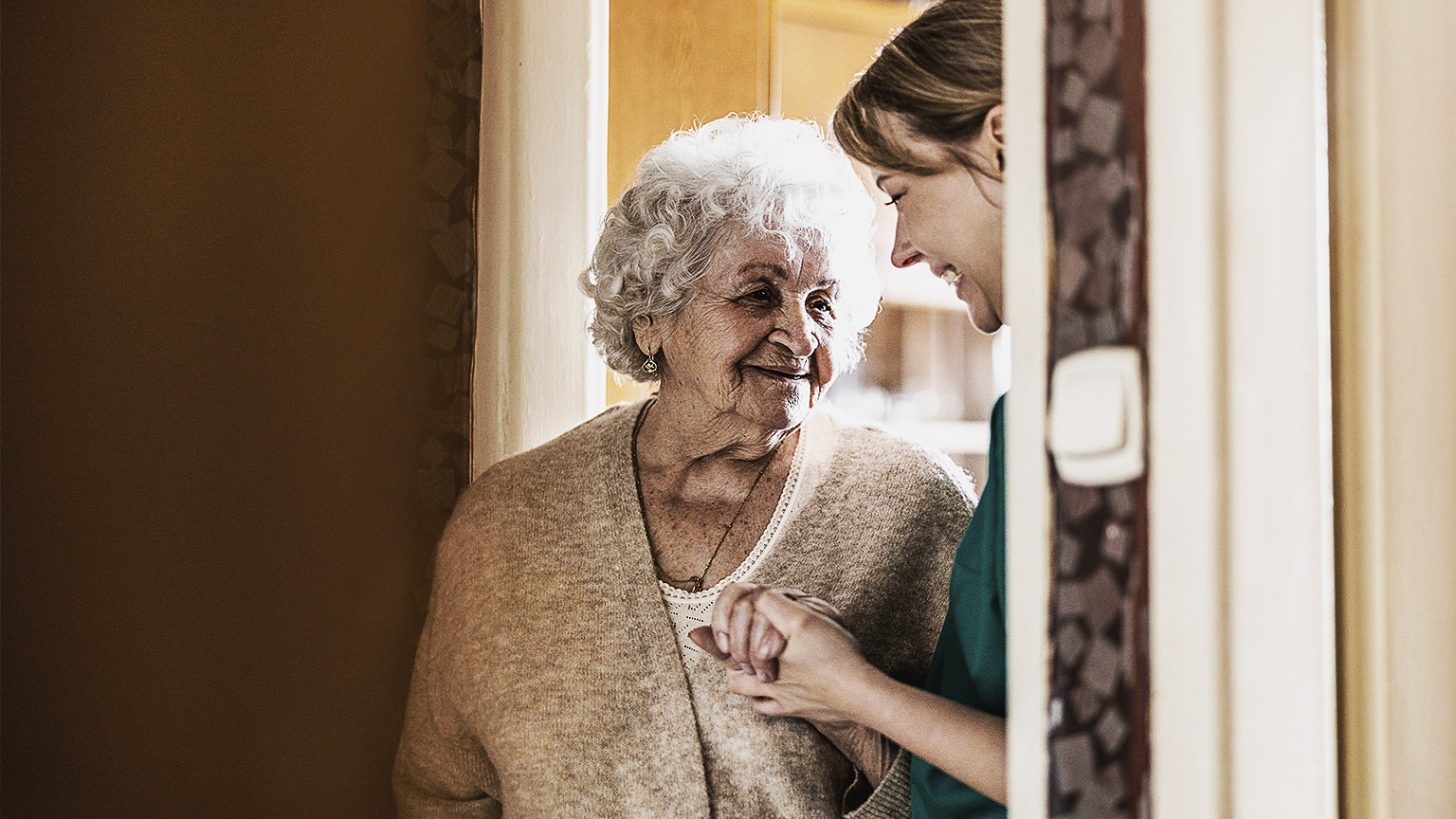 Worker supporting elderly woman