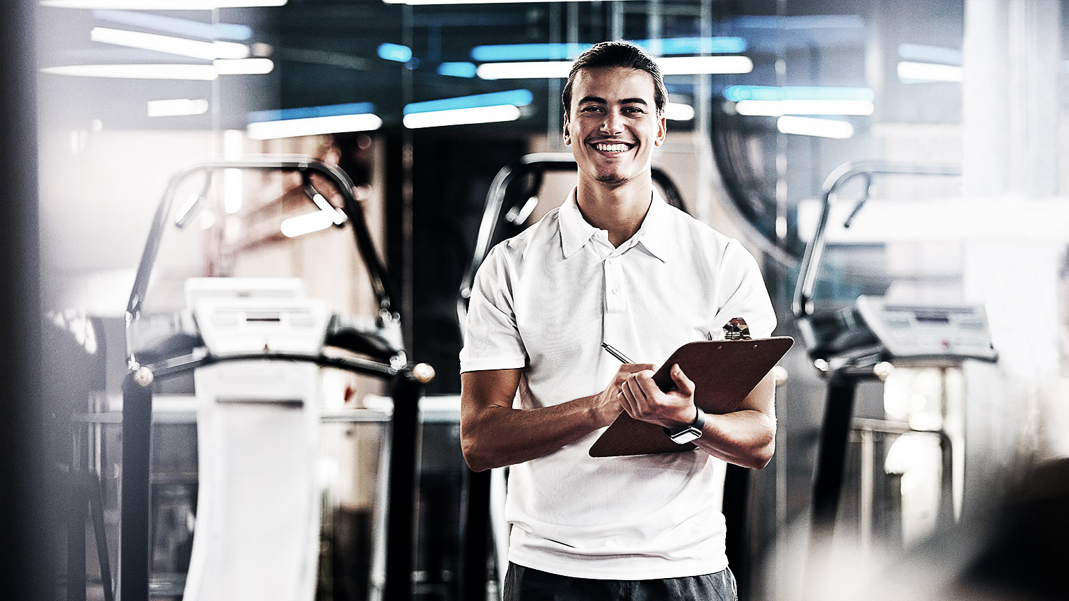 A trainer standing with a smile in the training gym