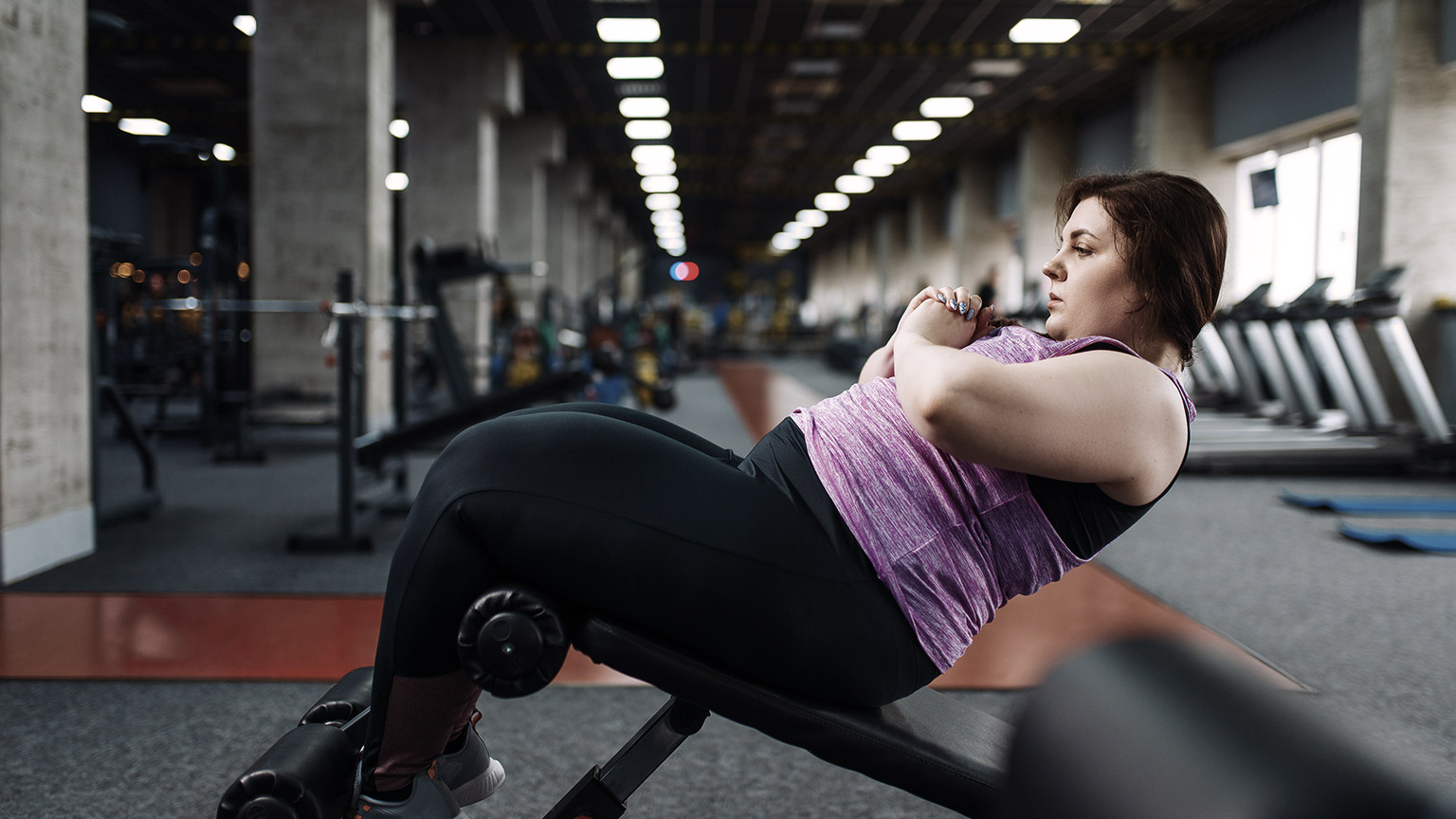 Overweight woman exercising on gym
