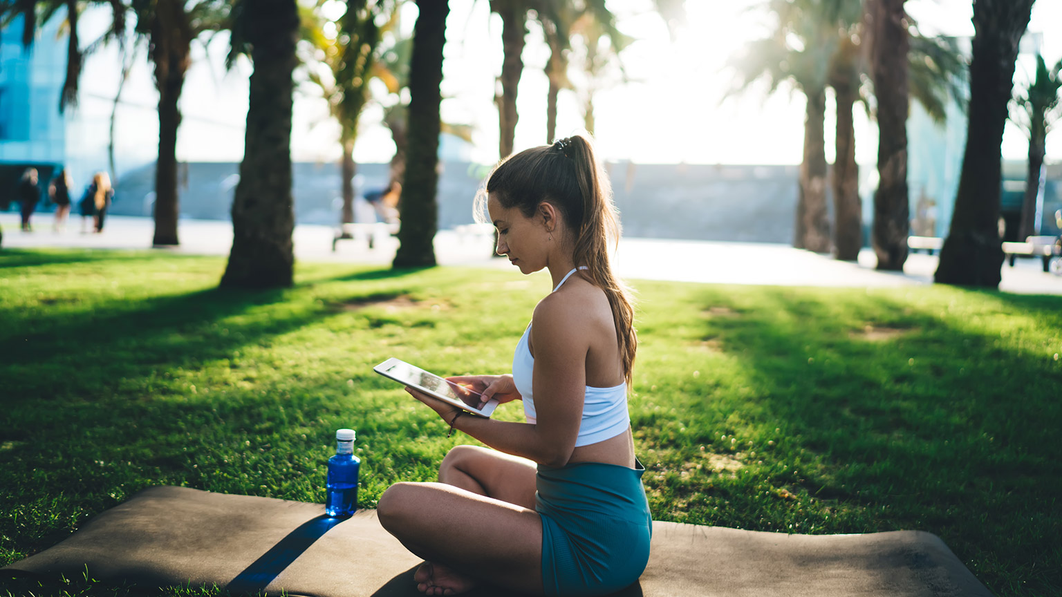 A person reading reference materials on a tablet device outdoors