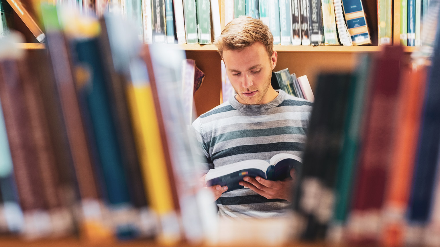 A student reading reference material in a library