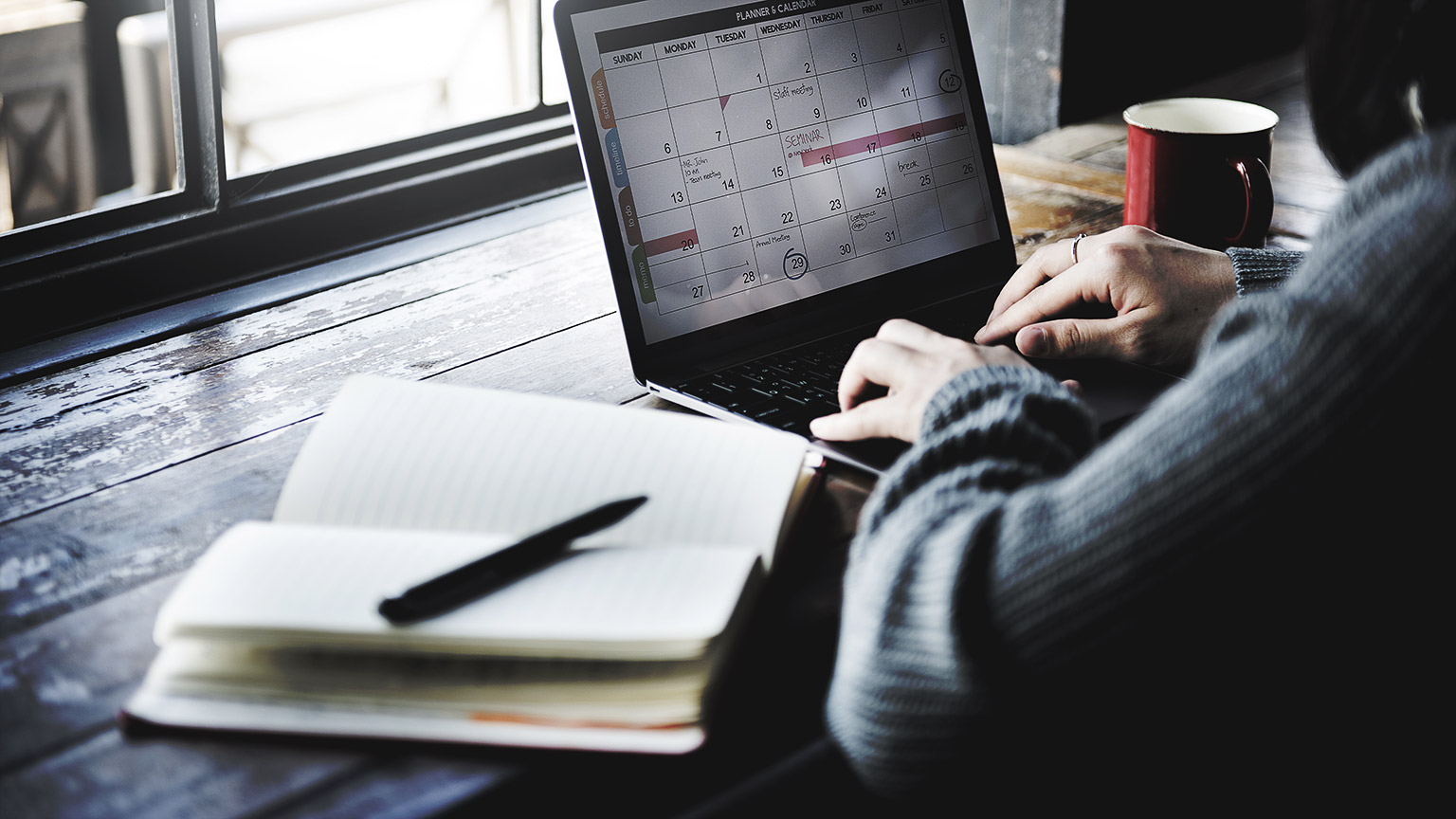 A person writing on a planner