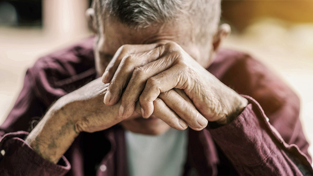 man covering his face with hands