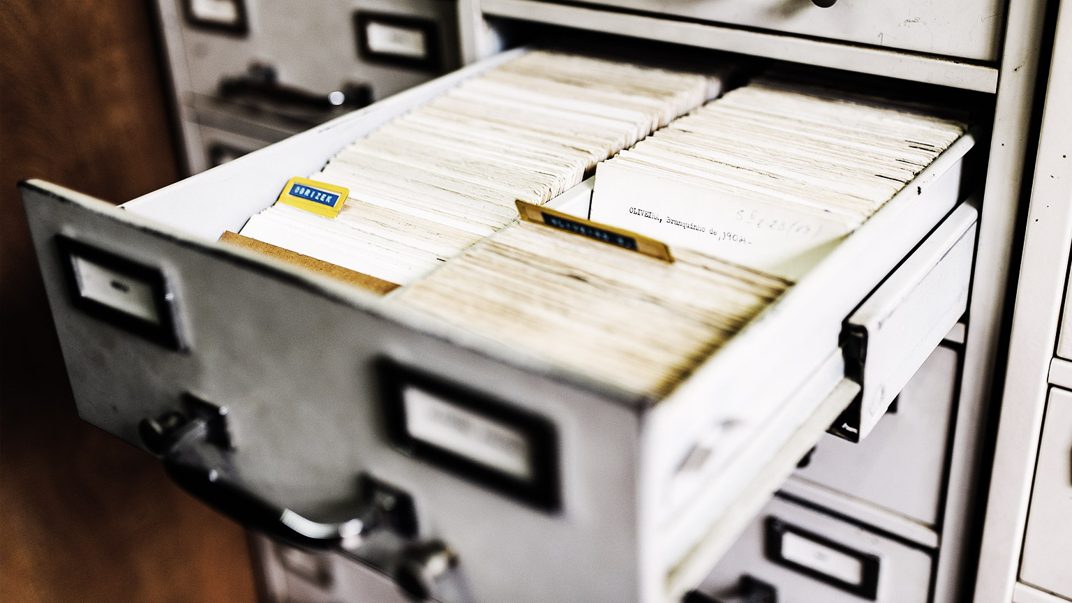 Businessmen are searching for documents inside a cabinet