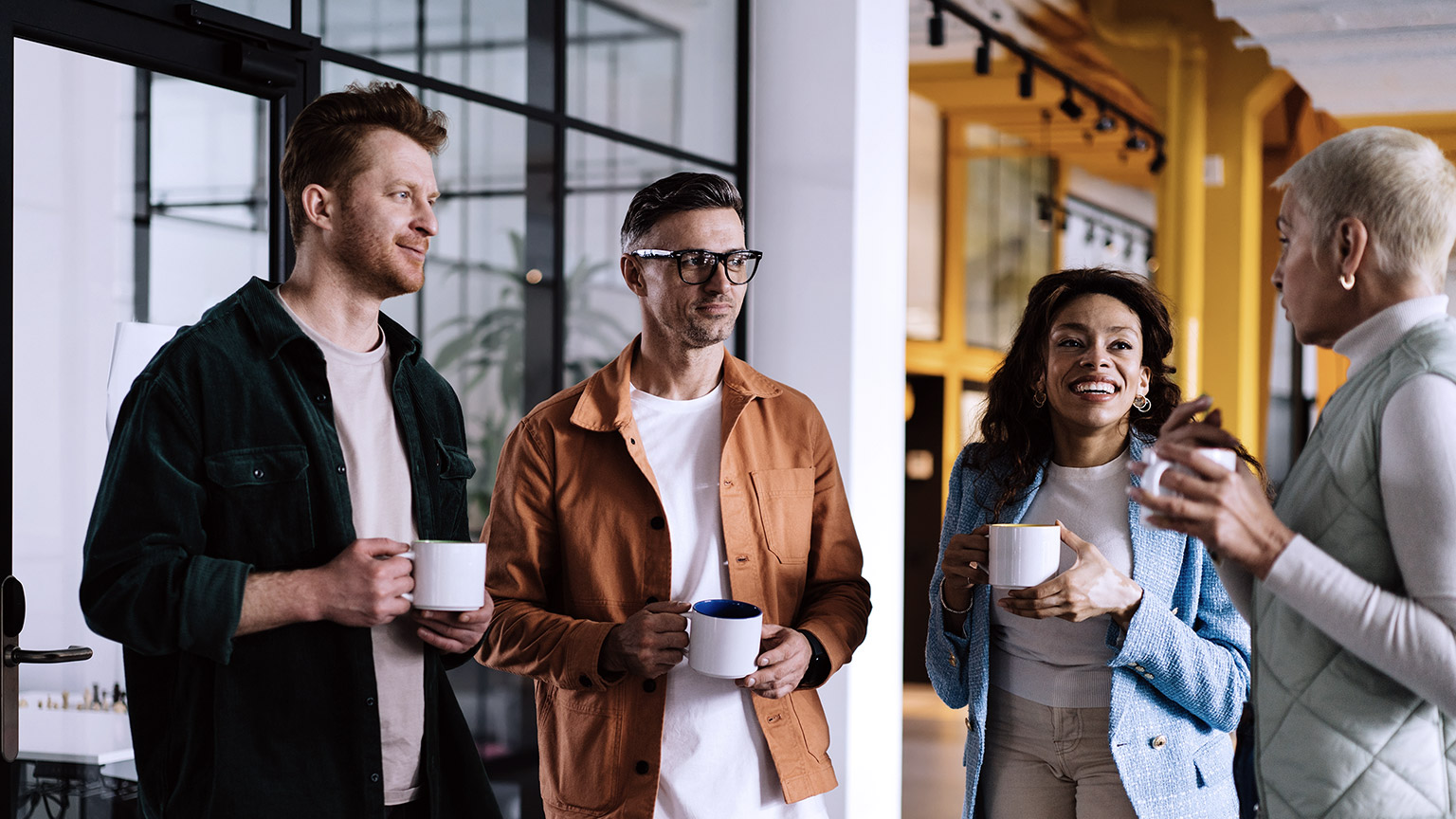 Workers talking with coffee while standing