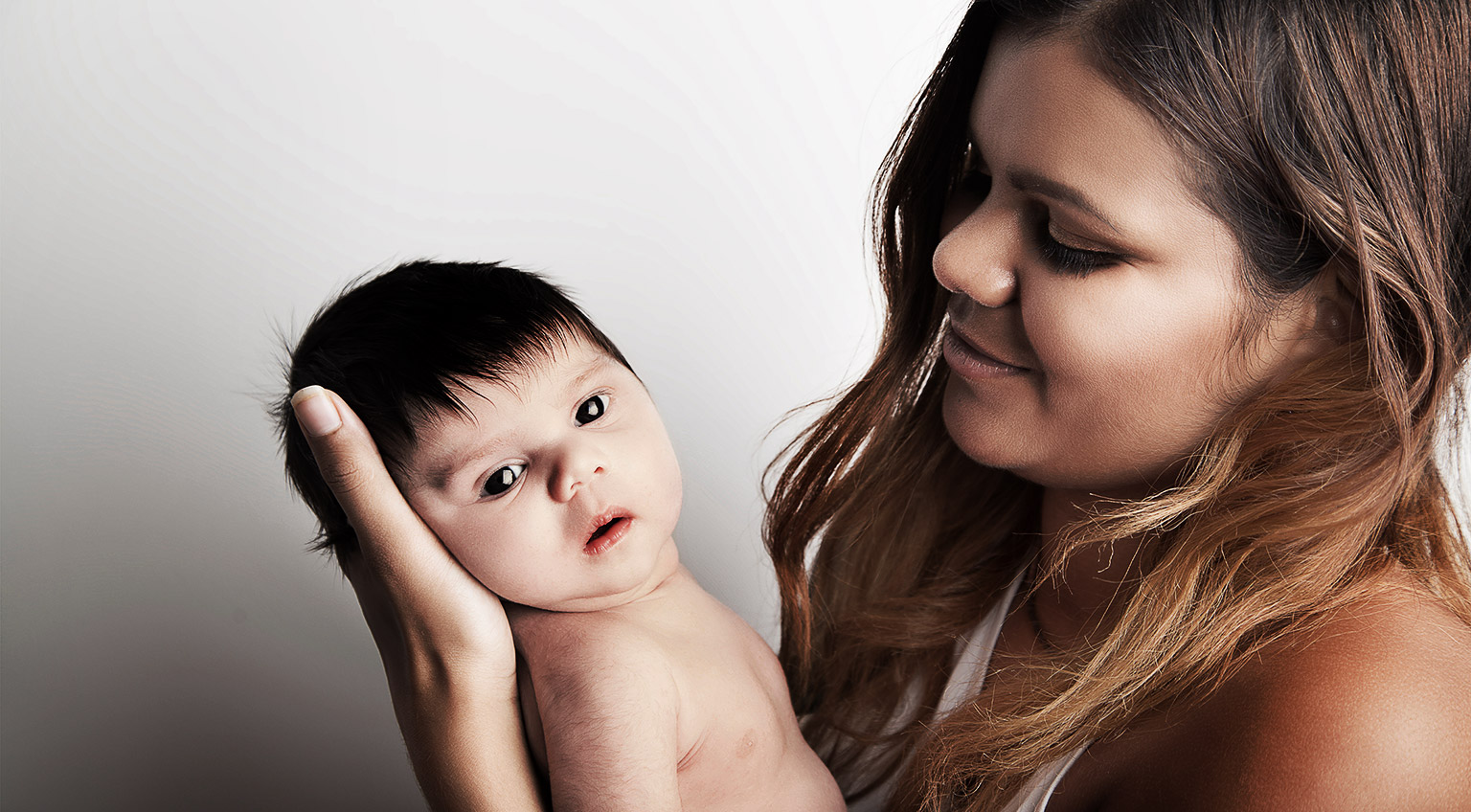 Young Australian mother holding her newborn baby girl.