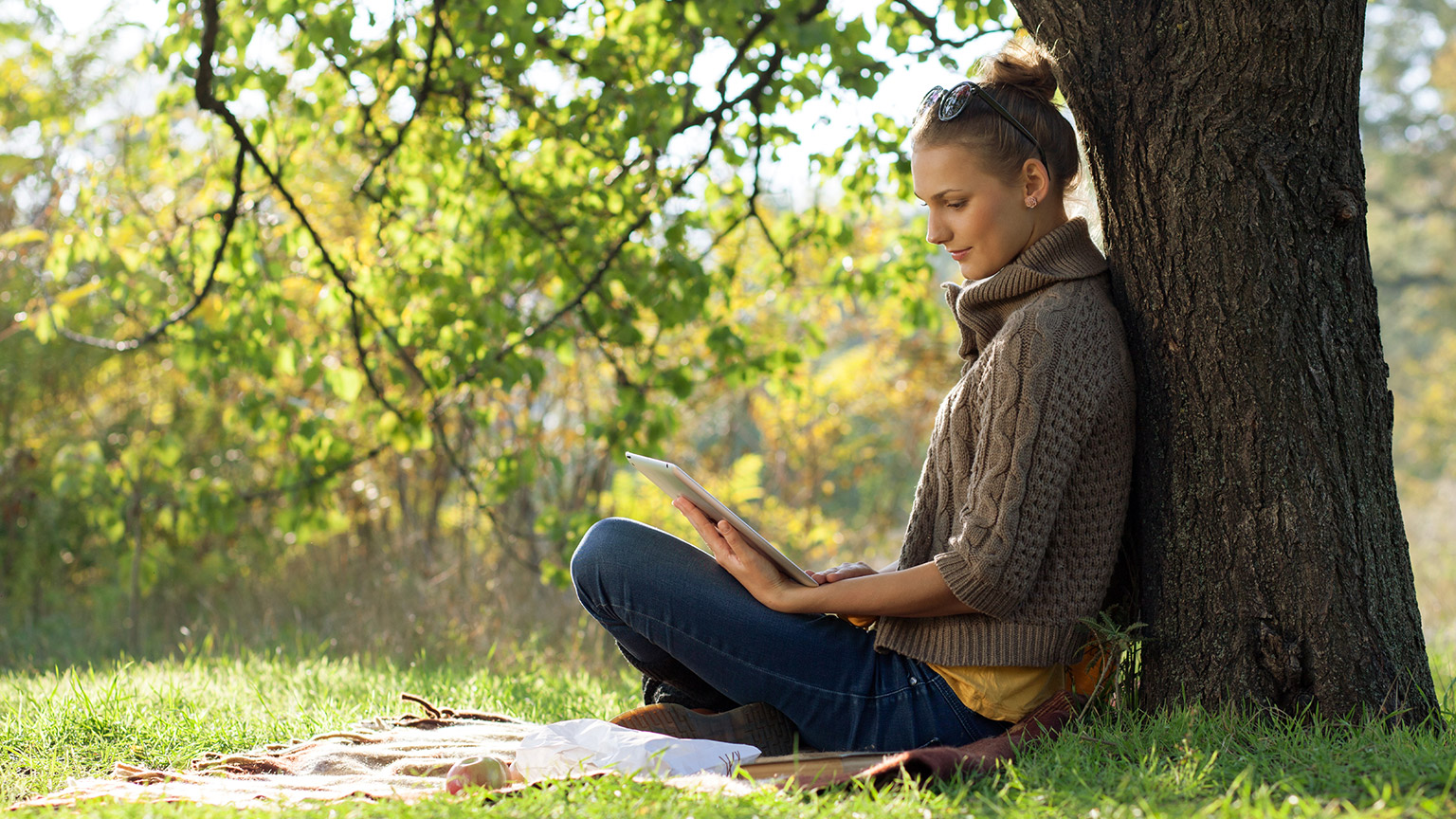 A person reading a tablet in an outdoor space