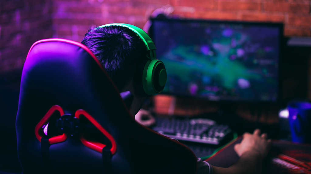 young gamer playing video games with headphones