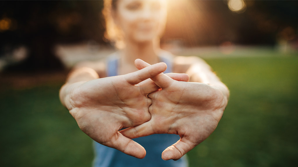 Young woman stretching arms outdoors