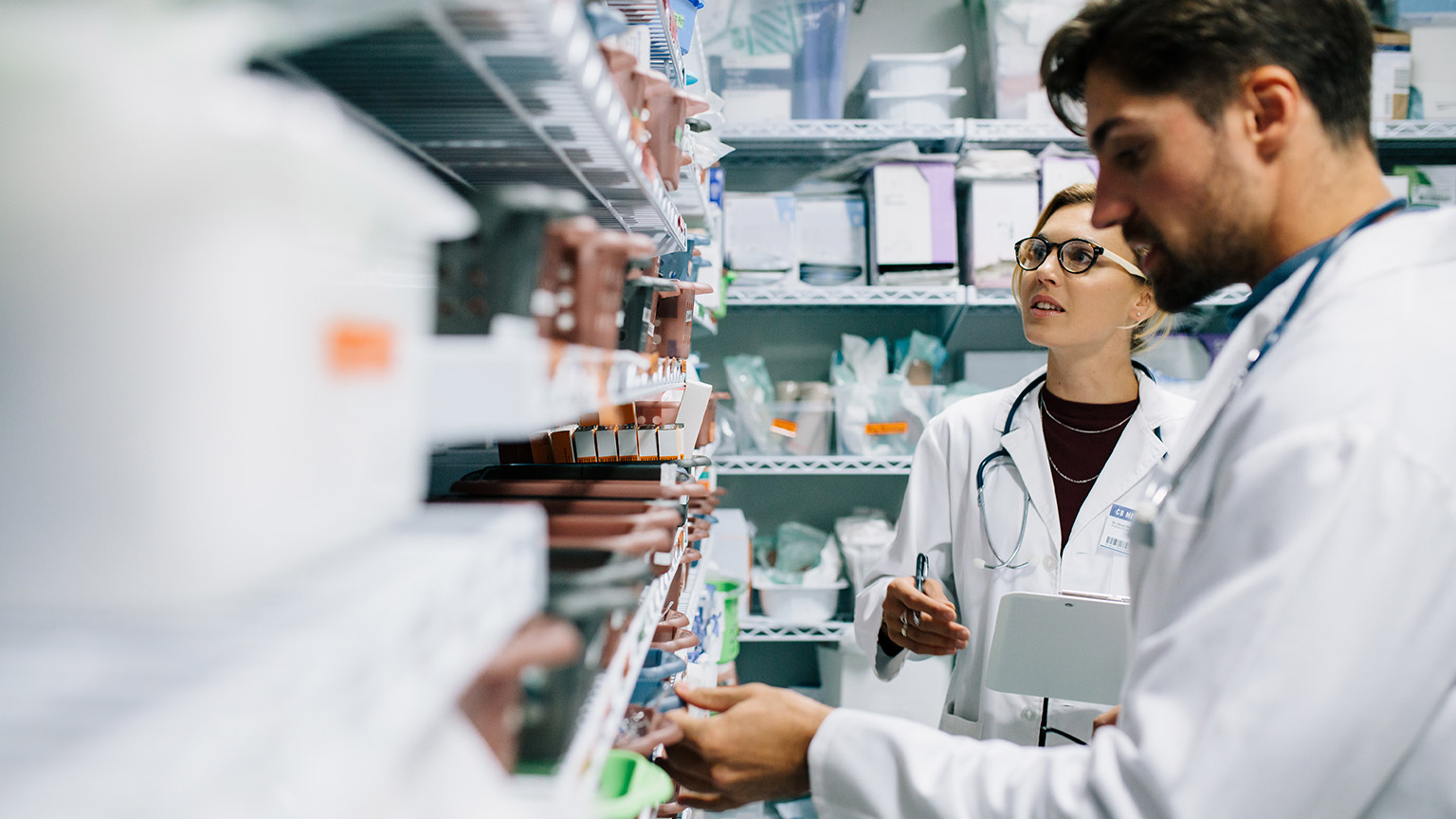 Two pharmacists checking medicines inventory at hospital pharmacy