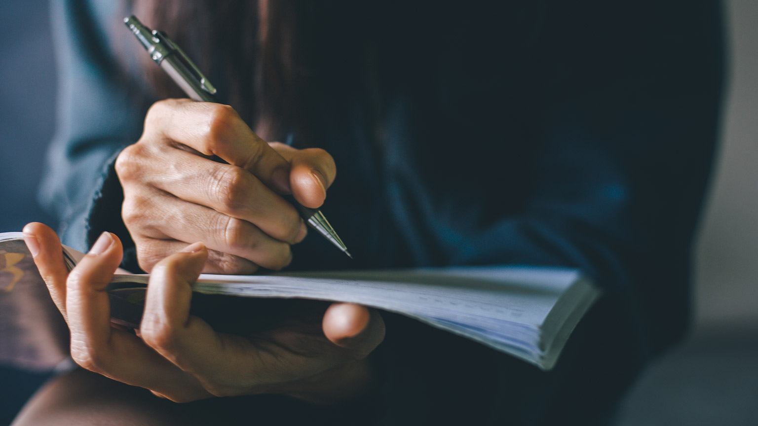 A person writing on a notebook