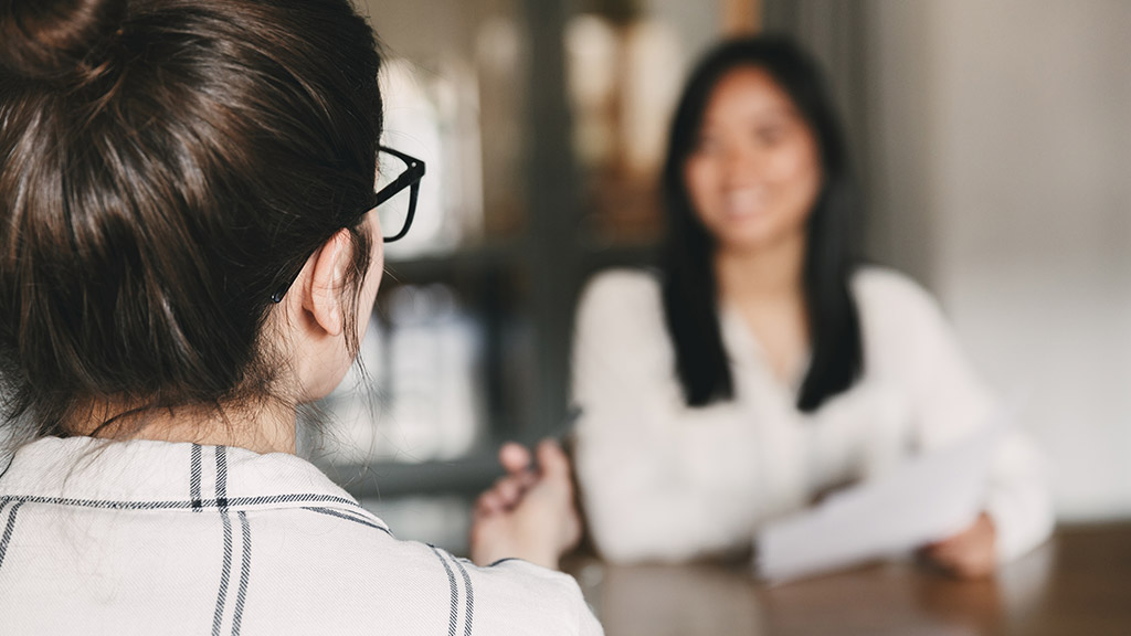 Business, career and placement concept -photo from back of businesswoman interviewing and talking with new female worker