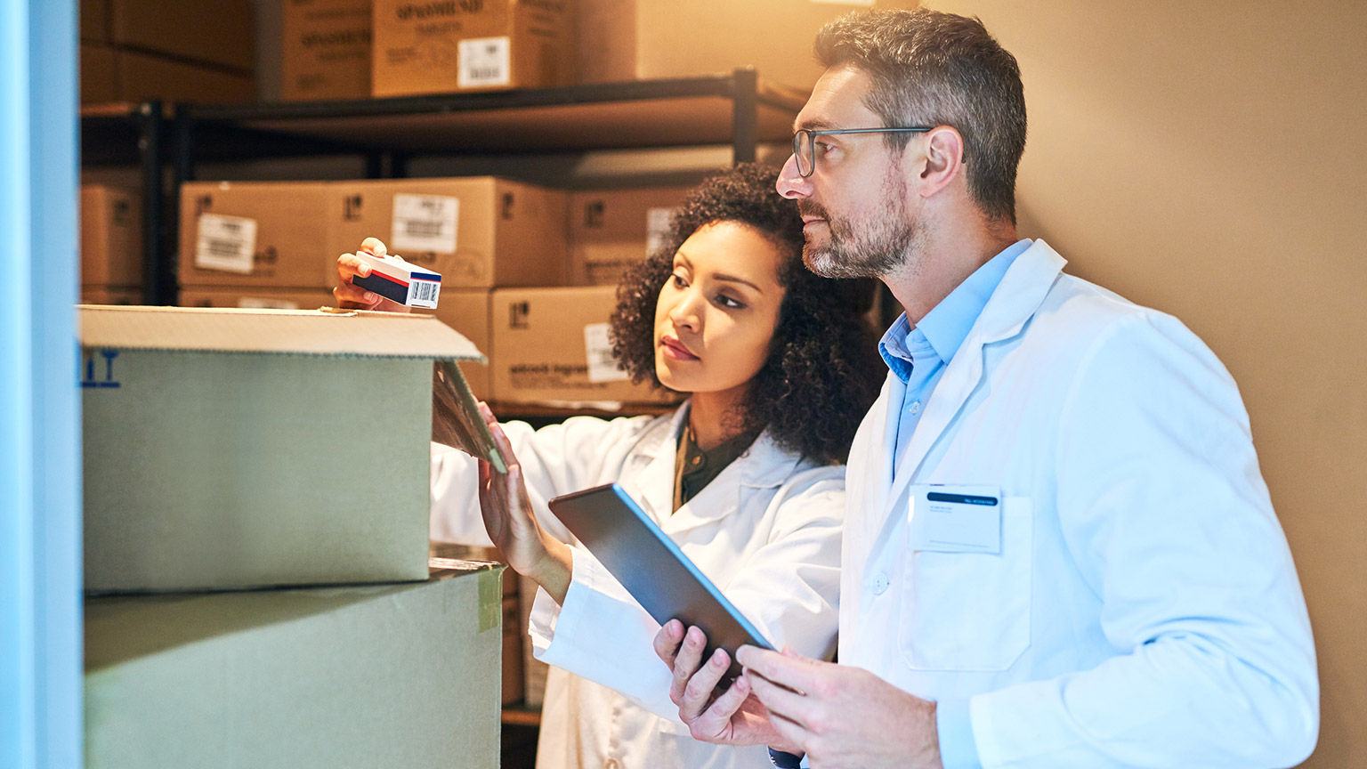 Pharmacists looking at contents of a box