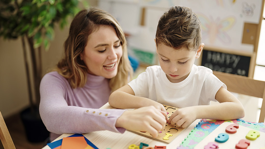 Woman and boy playing with maths puzzle